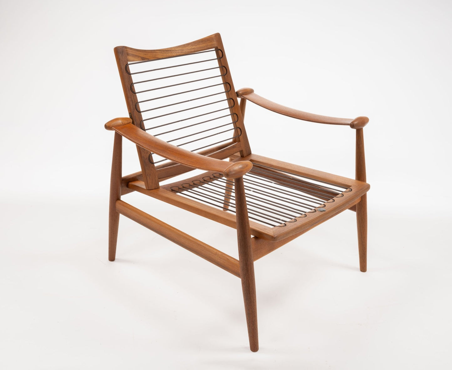Mid-century modern teak armchair with spade-shaped arms and woven cord seat and backrest on white background.