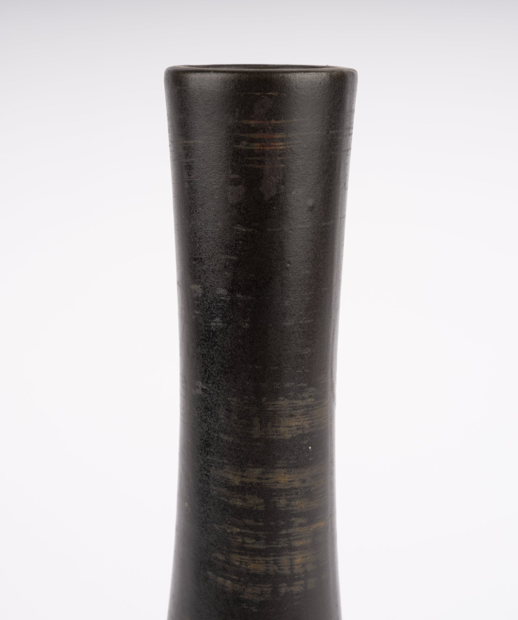 Close-up of tall slender neck on Nelson McCoy pottery vase with deep charcoal-black glaze and subtle tonal variations
