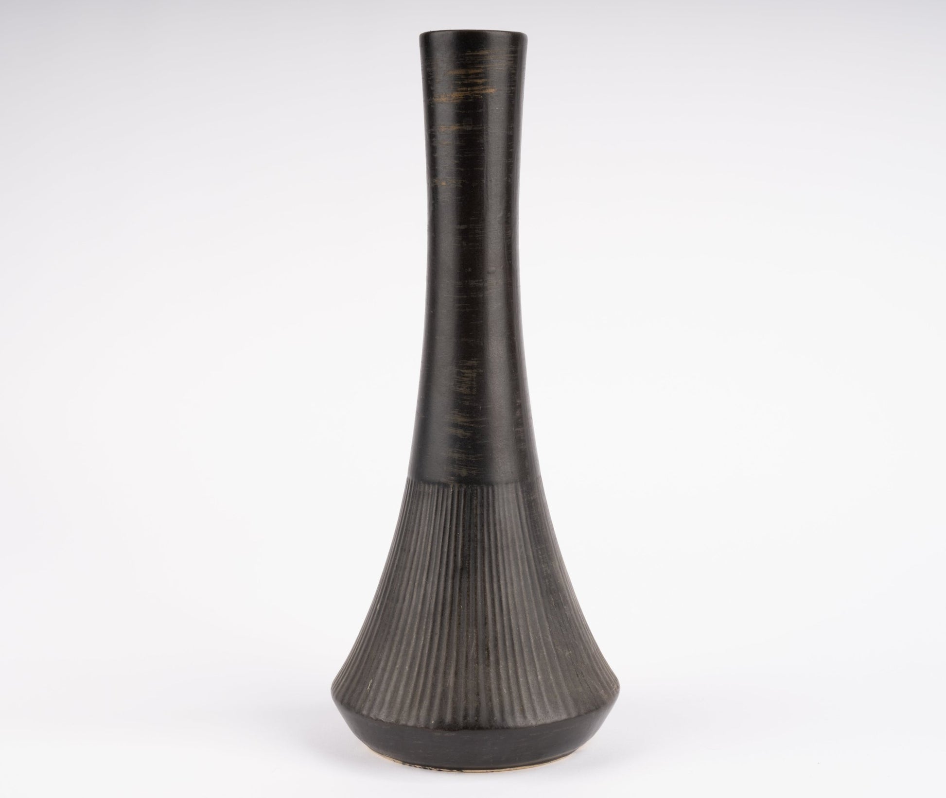 Tall Nelson McCoy pottery vase with slender neck and flared ribbed base in charcoal-black glaze
