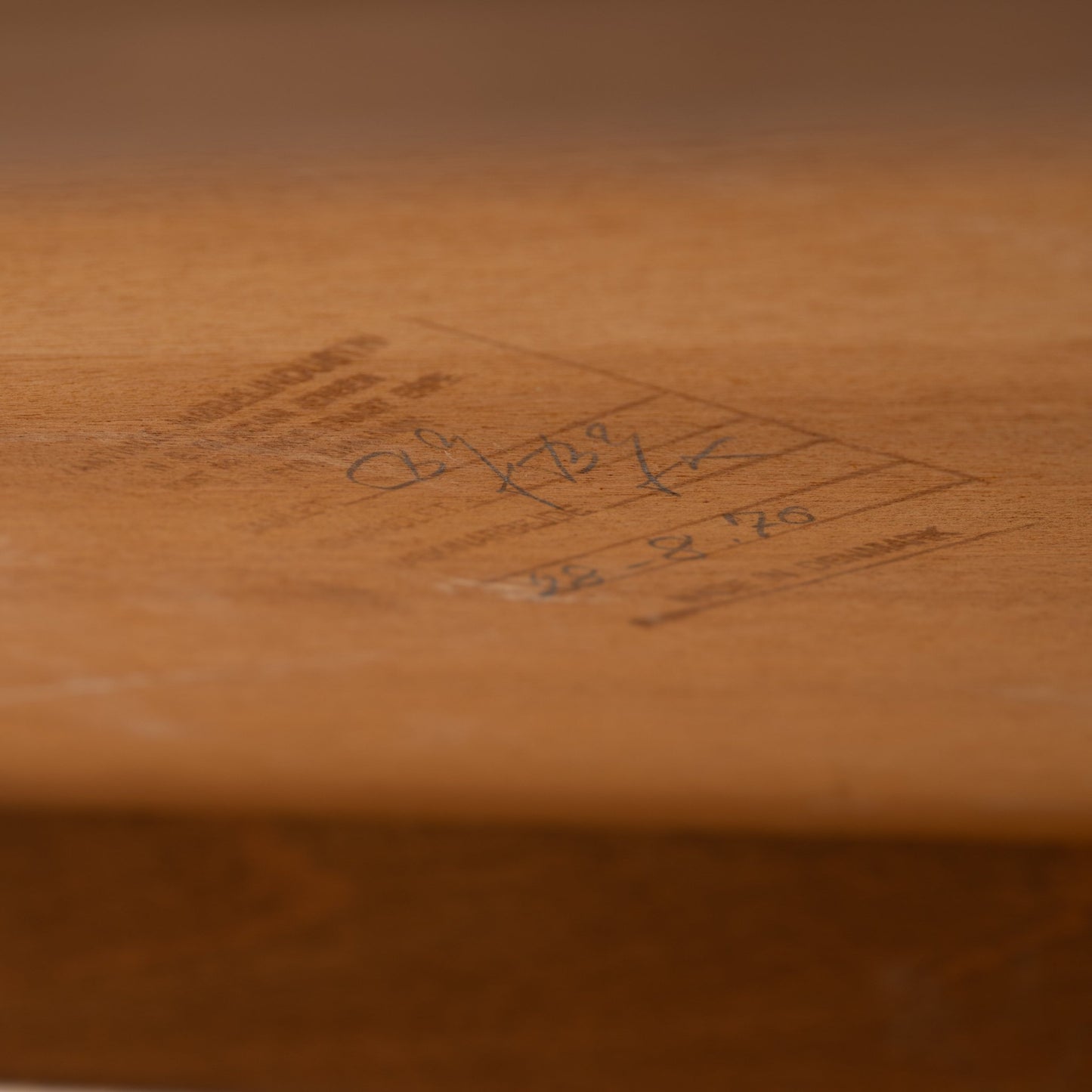 Niels Erik & Glasdam Jensen Teak Expanding Bar Cart detail showing close-up of its warm teak wood surface with handwritten vintage markings, highlighting authentic mid century modern craftsmanship.