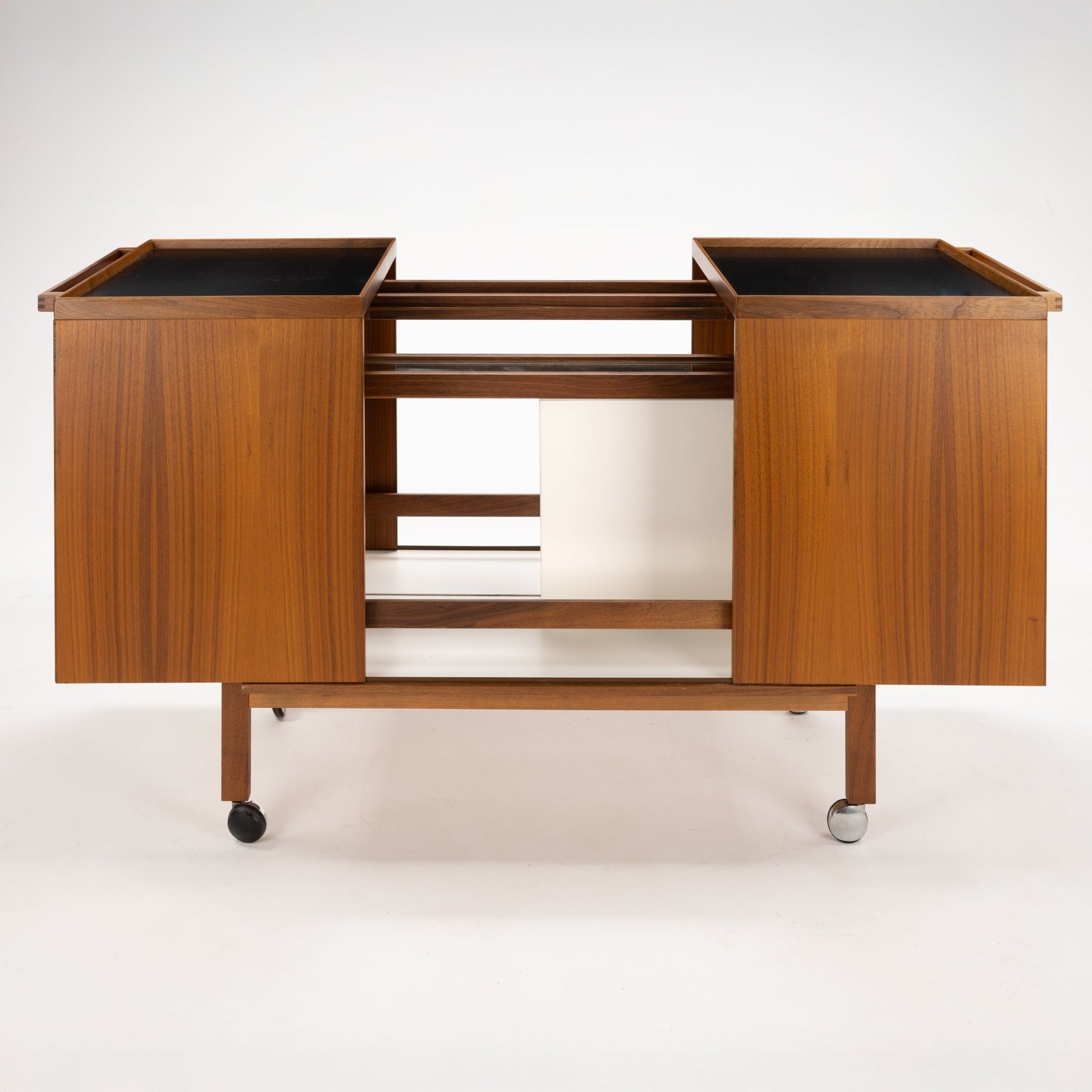 Niels Erik & Glasdam Jensen Teak Expanding Bar Cart with rich teak veneer panels, clean-lined design, expandable trays featuring dark surfaces, and durable caster wheels for versatile mid century modern storage and serving.