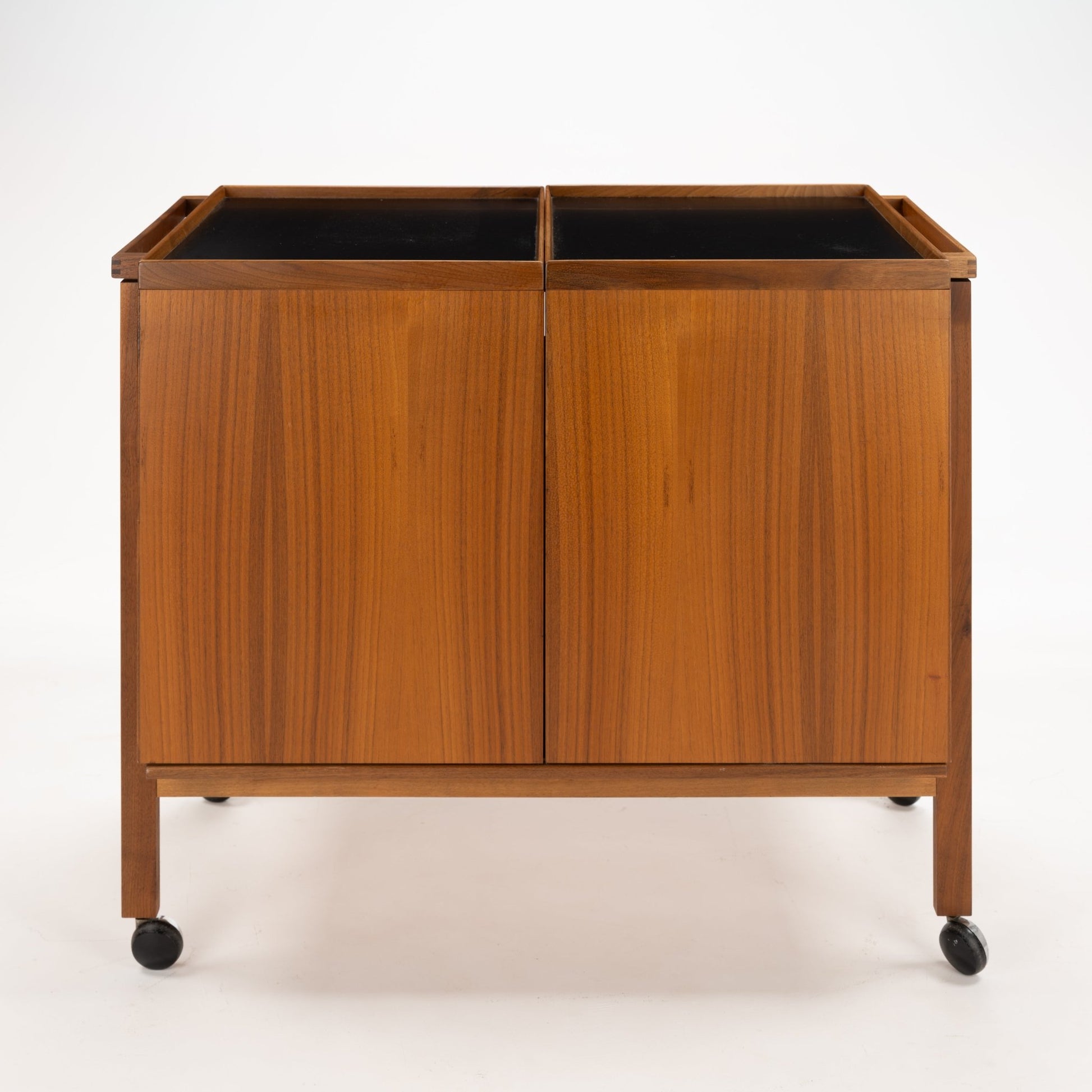 Niels Erik & Glasdam Jensen Teak Expanding Bar Cart showcasing a warm teak finish, clean rectangular panels, smooth black trays, and caster wheels for vintage Danish mid century modern storage and serving.