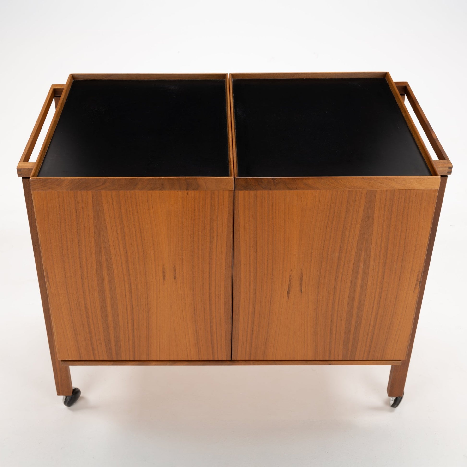 Niels Erik & Glasdam Jensen Teak Expanding Bar Cart with rich teak wood grain, sleek rectangular trays in dark finish, minimalist handles, and caster wheels for vintage Danish mid century modern storage.