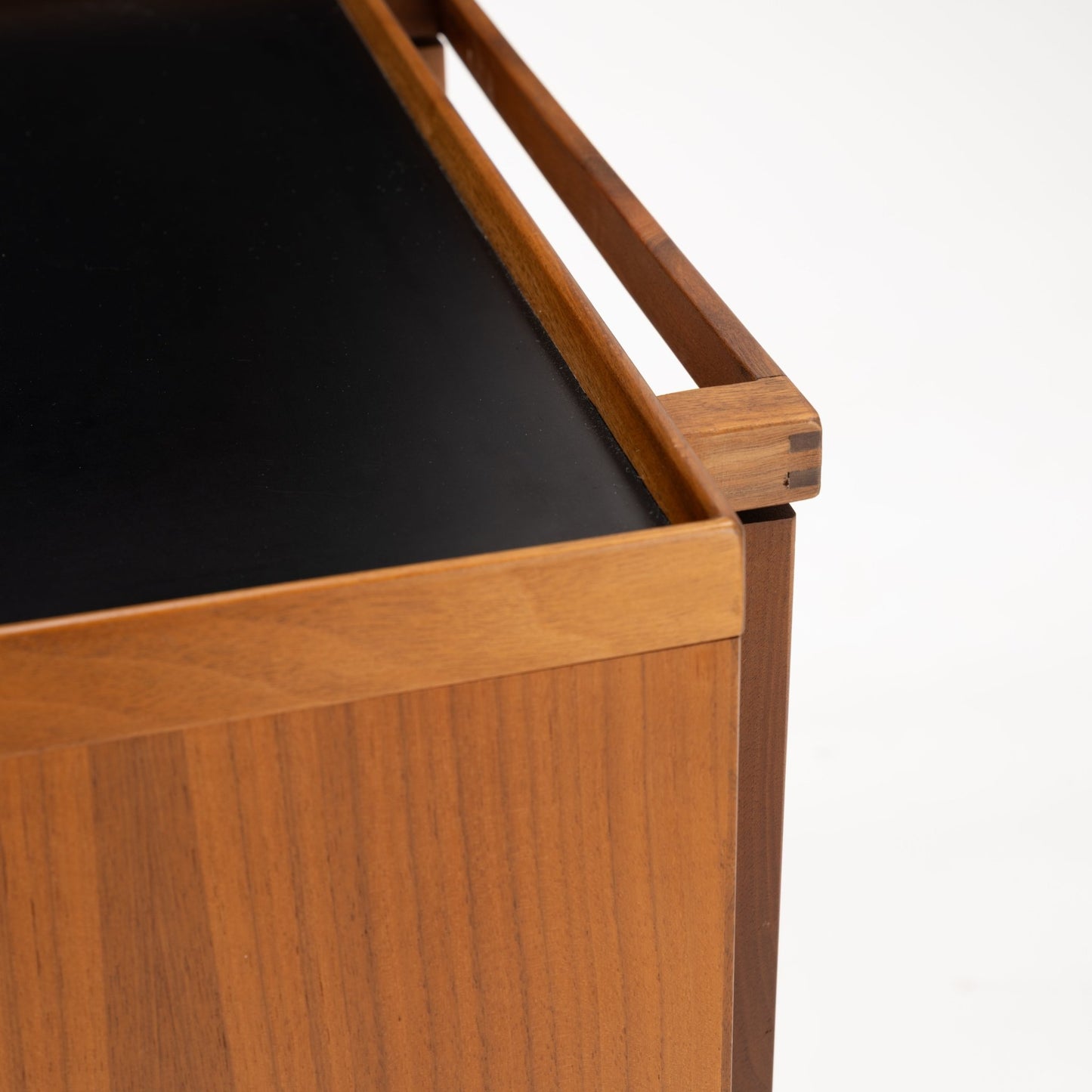 Niels Erik & Glasdam Jensen Teak Expanding Bar Cart close-up showing the smooth black tray surface, warm teak wood grain, and precise joinery details highlighting vintage Danish mid century modern storage design.