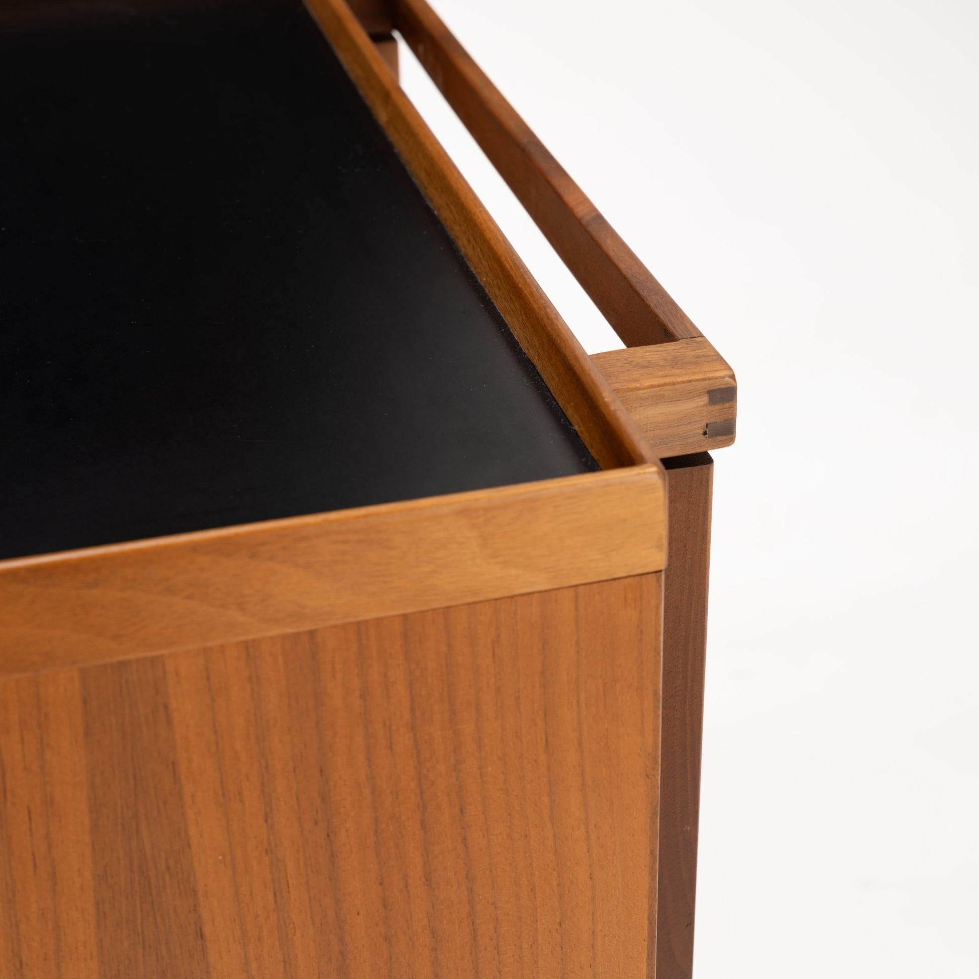 Niels Erik & Glasdam Jensen Teak Expanding Bar Cart close-up showing the smooth black tray surface, warm teak wood grain, and precise joinery details highlighting vintage Danish mid century modern storage design.