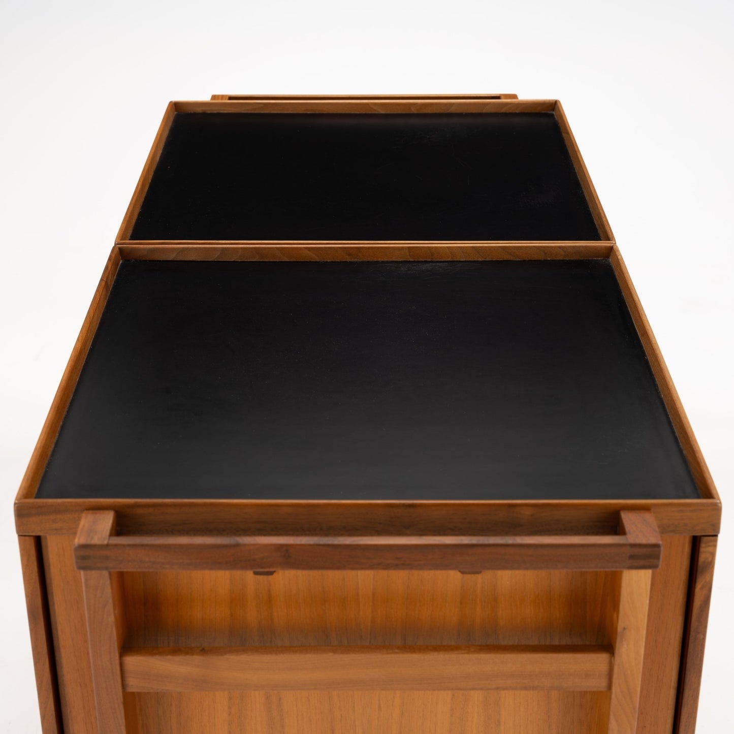 Niels Erik & Glasdam Jensen Teak Expanding Bar Cart with smooth black tray surfaces, warm teak frame, a sturdy handle, and an open shelving section, exemplifying vintage Danish mid century modern furniture.