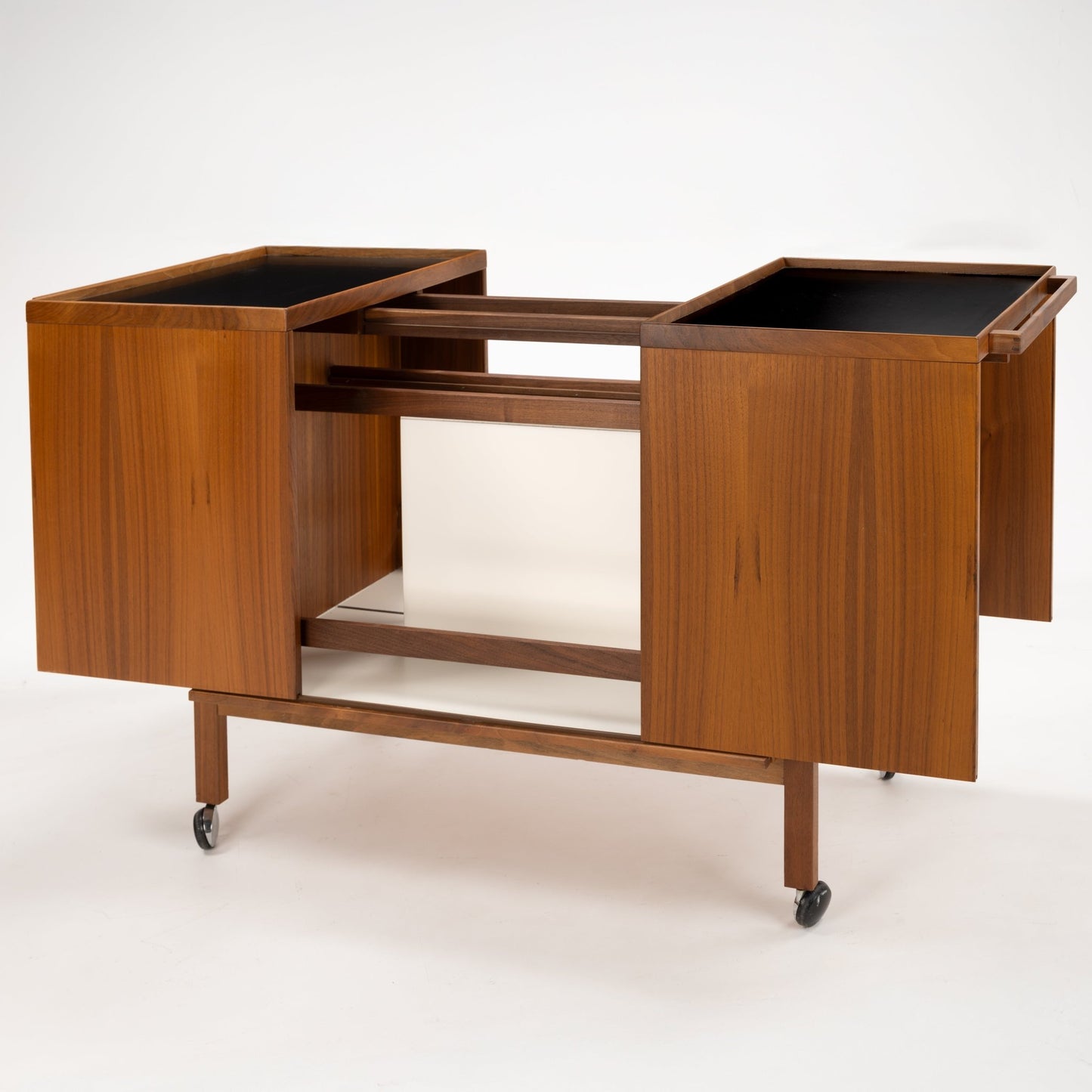 Niels Erik & Glasdam Jensen Teak Expanding Bar Cart with rich teak panels, sleek black tray tops, expandable sides, and caster wheels, showcasing vintage Danish mid century modern storage.
