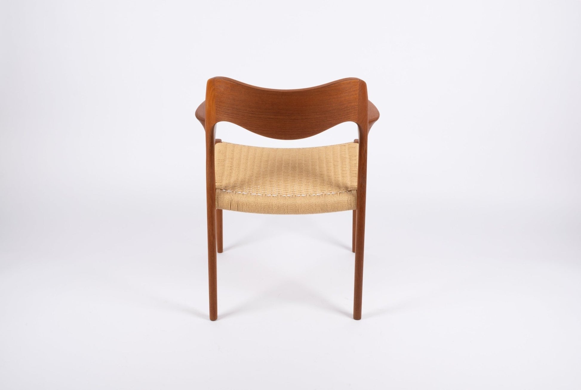 Mid-century modern Niels Moller dining chair in solid teak with sculpted backrest and woven Danish cord seat.