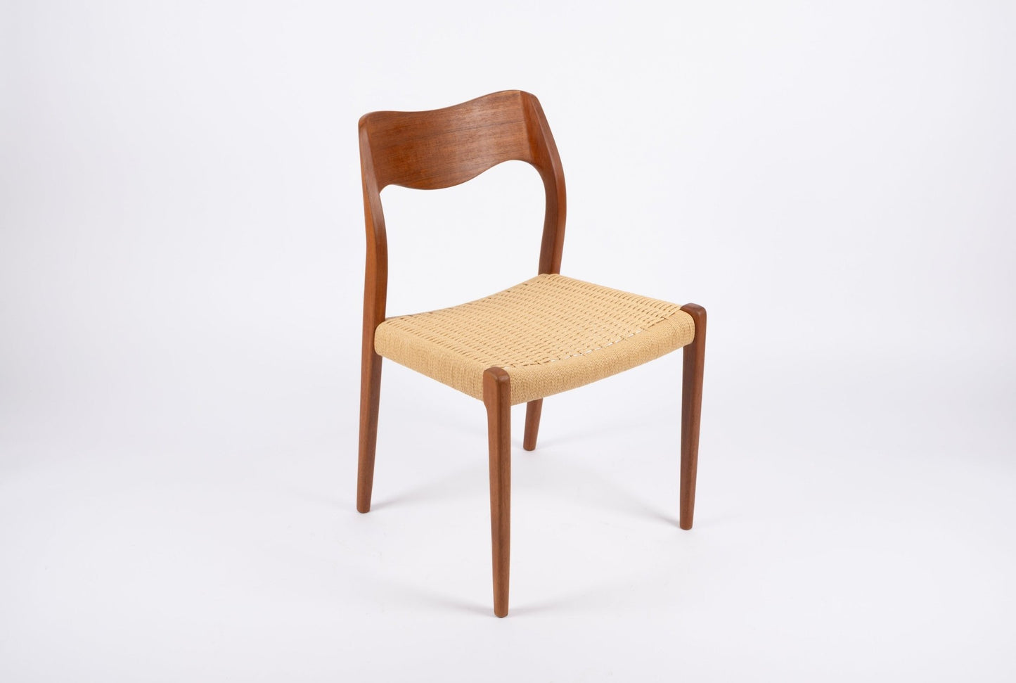 Mid-century modern Niels Moller dining chair in solid teak with sculpted backrest and woven Danish cord seat.