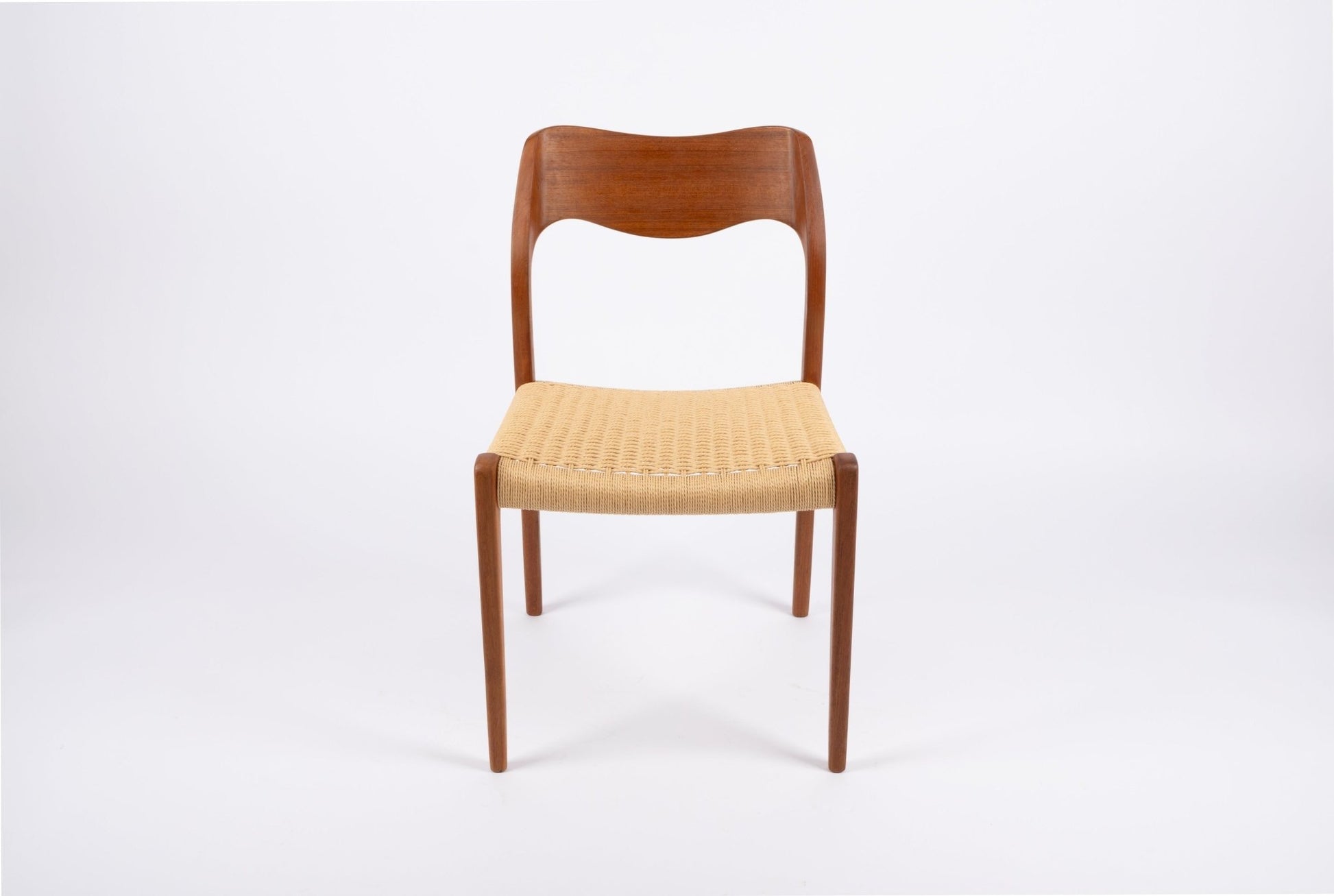 Mid-century modern Niels Moller teak dining chair with sculpted curved backrest and woven Danish cord seat.