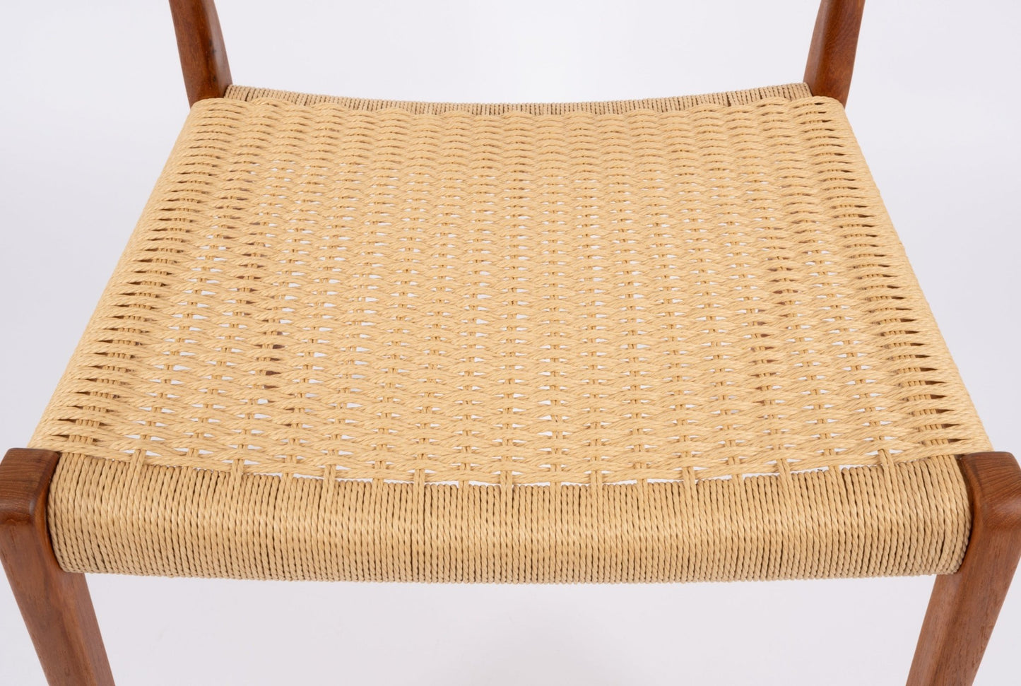 Close-up of woven Danish cord seat on mid-century modern Niels Moller teak dining chair