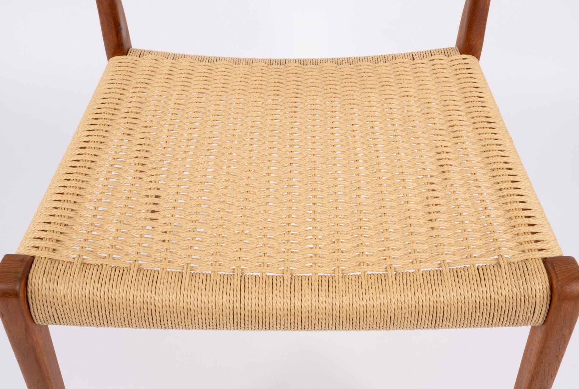 Close-up of woven Danish cord seat on mid-century modern Niels Moller teak dining chair
