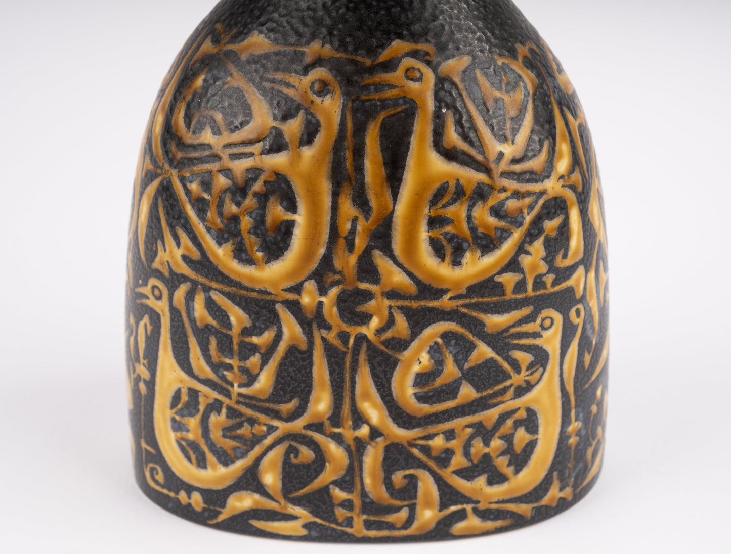 Close-up of Nils Thorsson fajance vase with intricate raised bird and floral pattern, mid-century Danish ceramic design