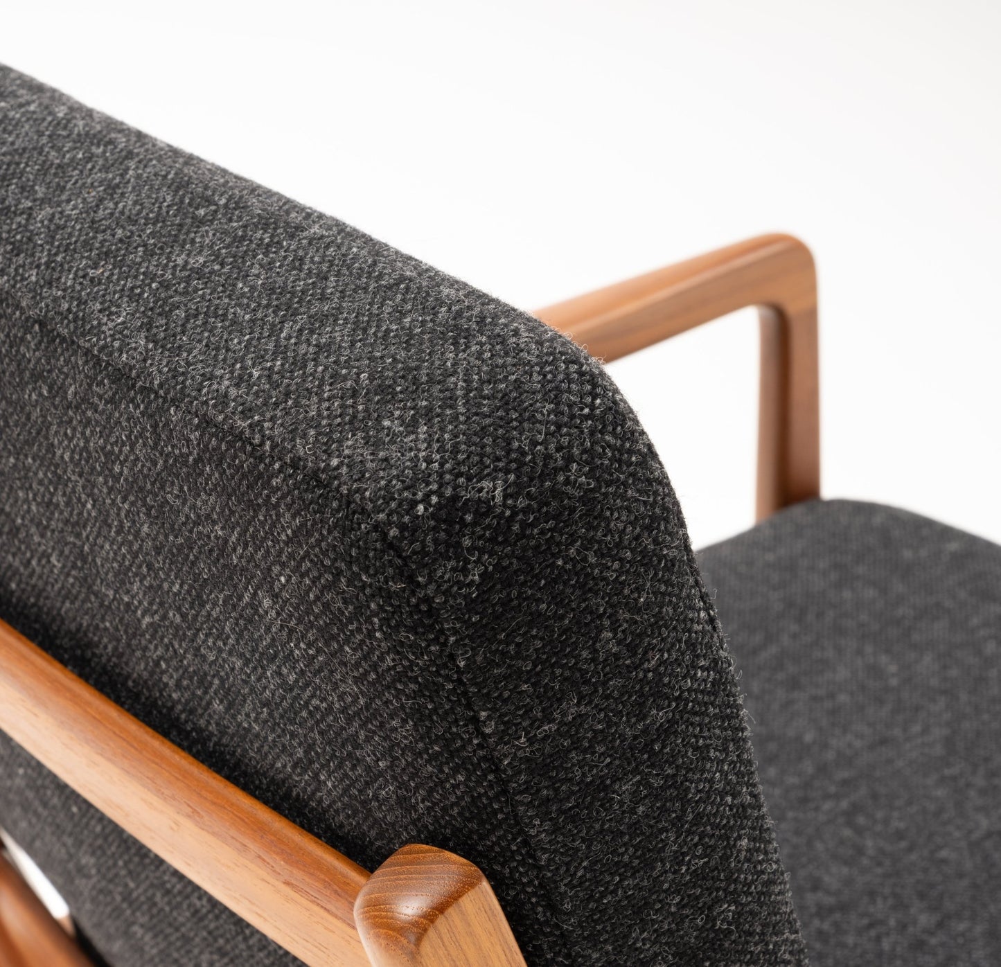 Close-up of Ole Wanscher Rocking Chair with solid teak frame and dark gray upholstered backrest and seat.