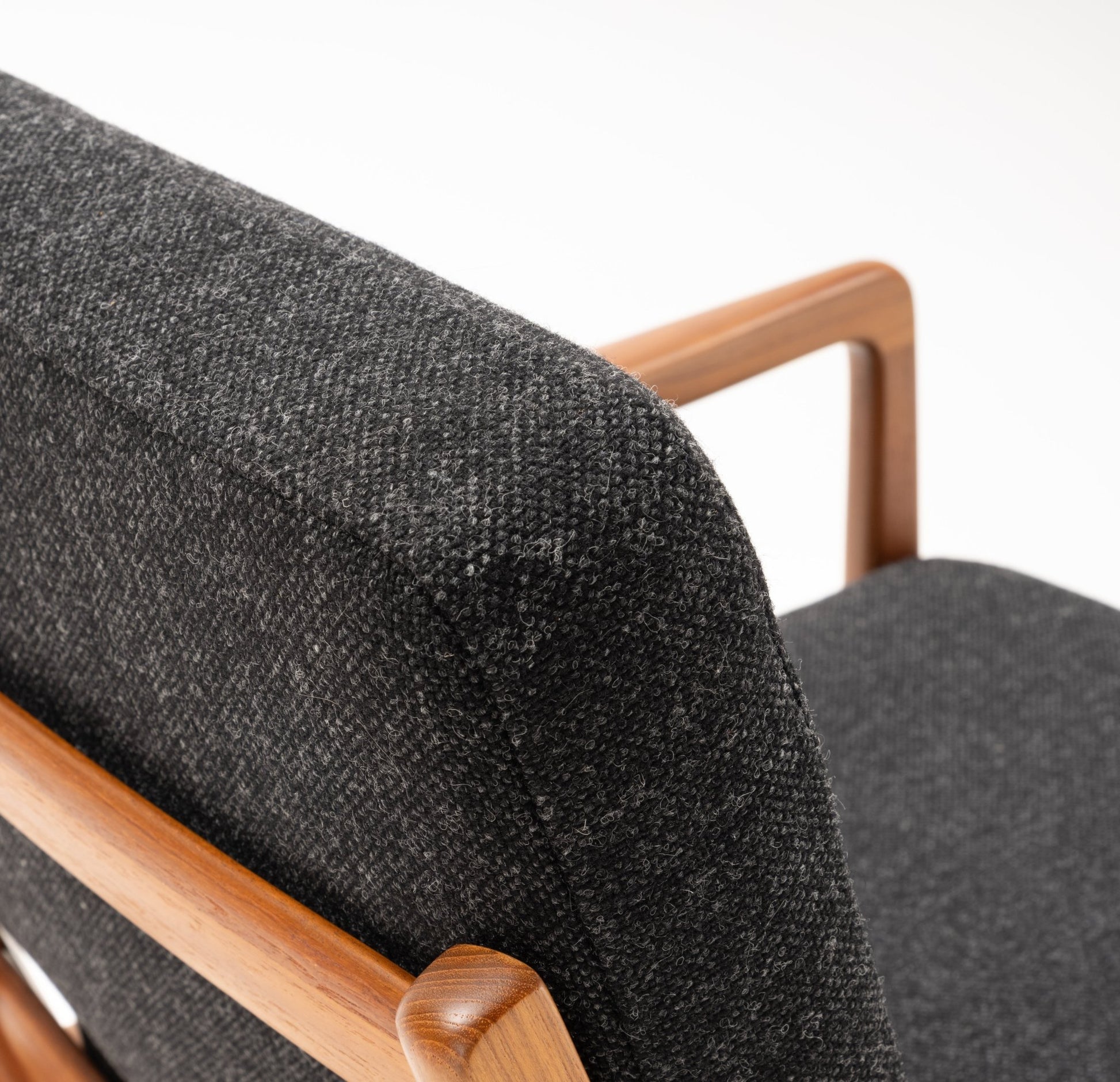 Close-up of Ole Wanscher Rocking Chair with solid teak frame and dark gray upholstered backrest and seat.