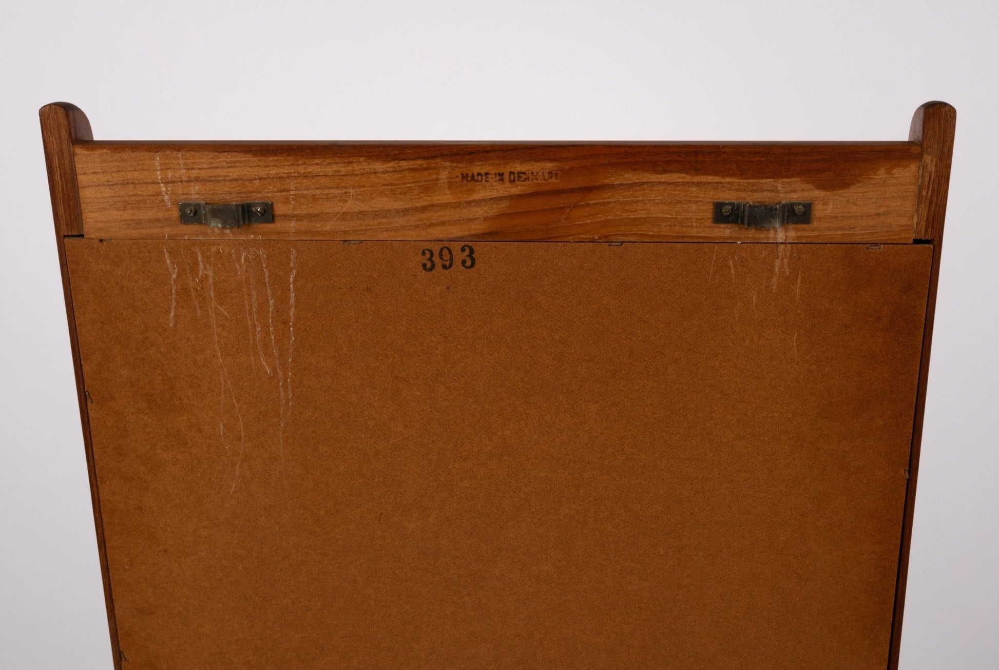 Back view of 1960s Pedersen & Hansen teak wall mirror showing metal eyes, maker's mark, and wooden frame details.
