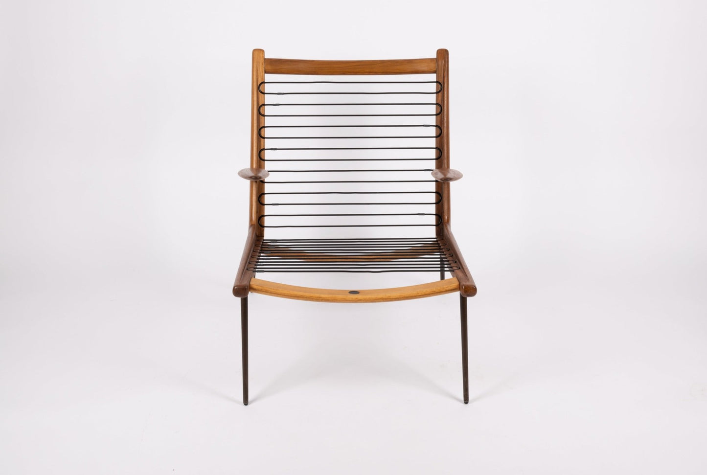 Peter Hvidt "Boomerang" armchair with curved teak frame and slender brass legs on white background