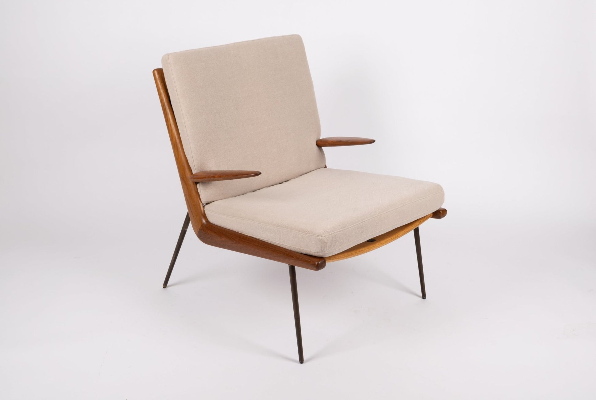 Pair of mid-century modern Peter Hvidt Boomerang armchairs with teak frame, beige cushions, and brass legs
