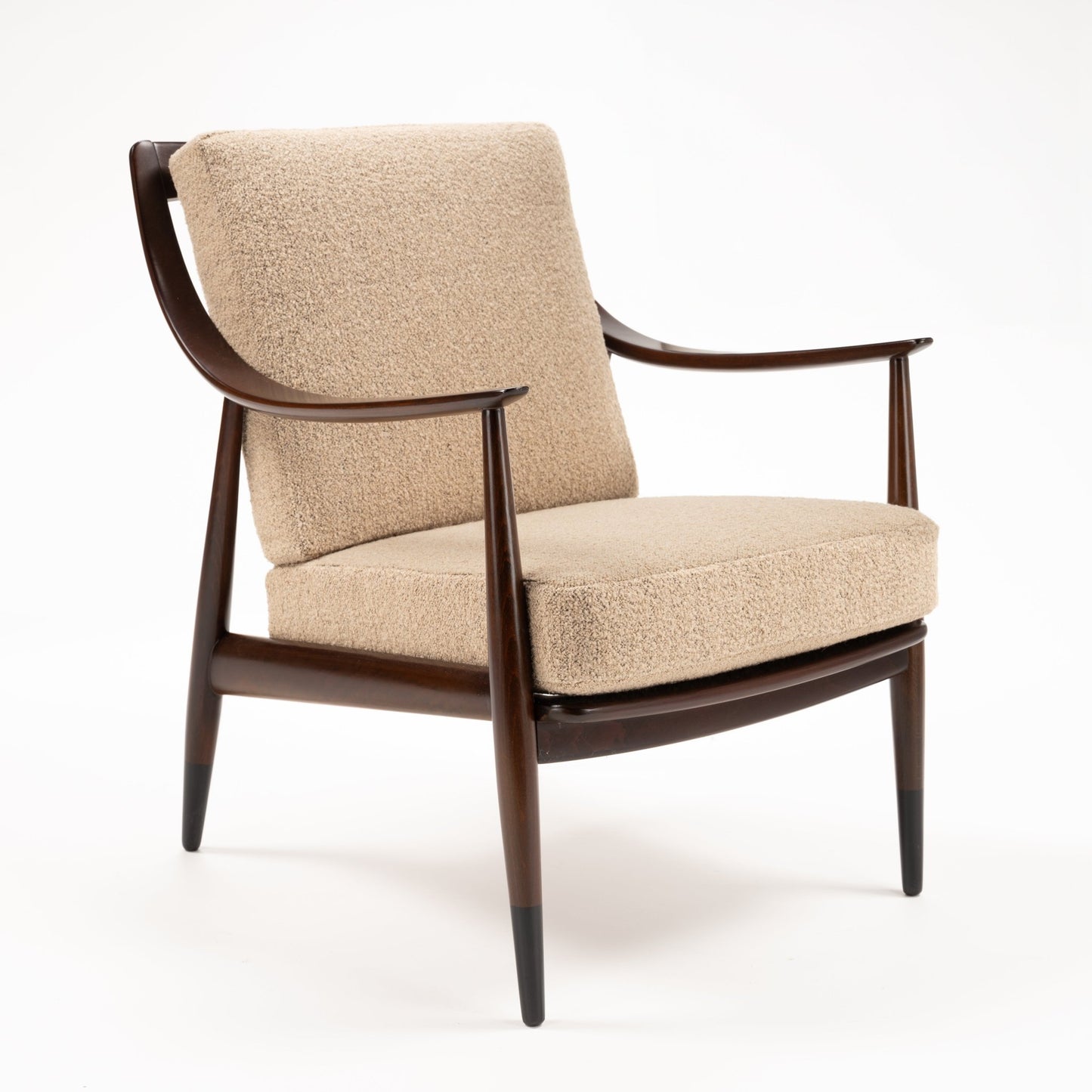 Peter Hvidt Model FD 145 Lounge Chair in dark sculpted wood with curved arms beige boucle upholstery and tapered legs in vintage Danish furniture style