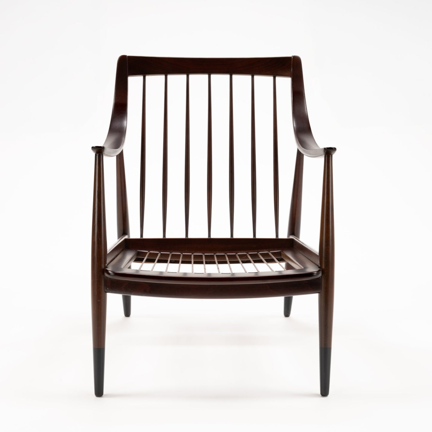 Peter Hvidt Model FD 145 Lounge Chair with dark sculpted wood frame curved arms spindle back and exposed seat springs in vintage Danish furniture style