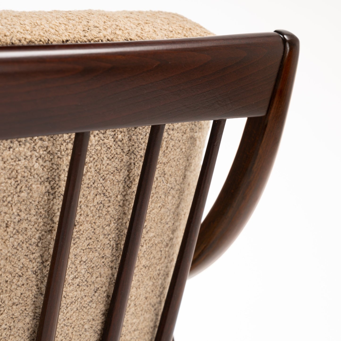 Peter Hvidt Model FD 145 Lounge Chair close view of dark sculpted wood back rail curved frame spindle details and textured beige upholstery in vintage Danish furniture style