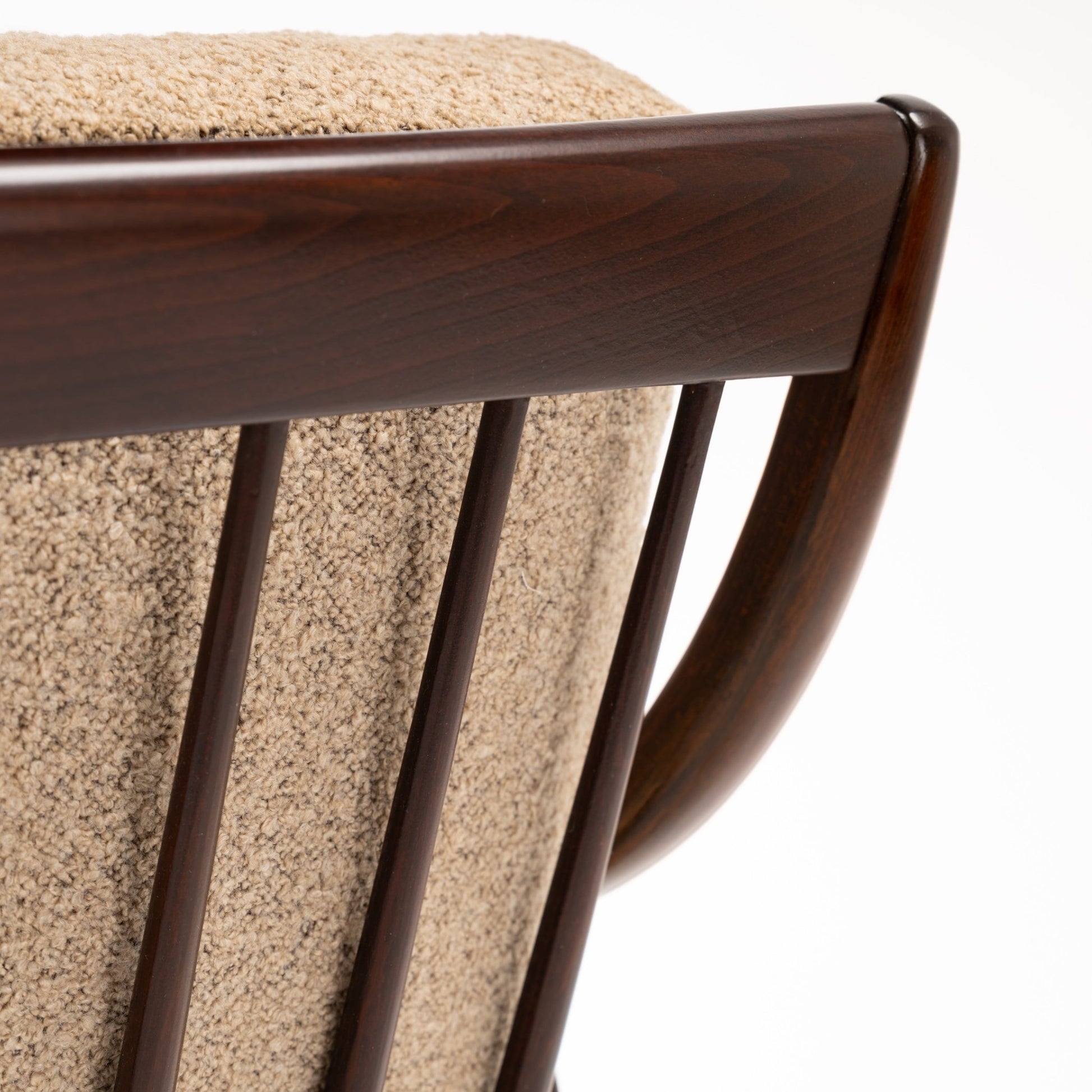 Peter Hvidt Model FD 145 Lounge Chair close view of dark sculpted wood back rail curved frame spindle details and textured beige upholstery in vintage Danish furniture style