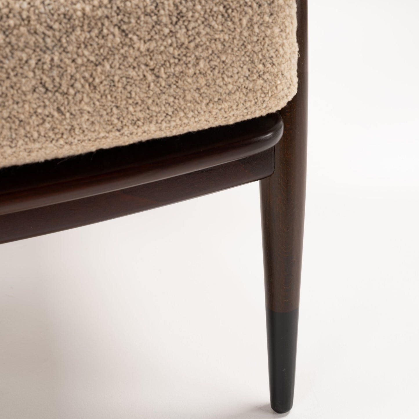 Peter Hvidt Model FD 145 Lounge Chair close detail of textured beige upholstery dark wood seat rail and tapered leg in vintage Danish furniture style