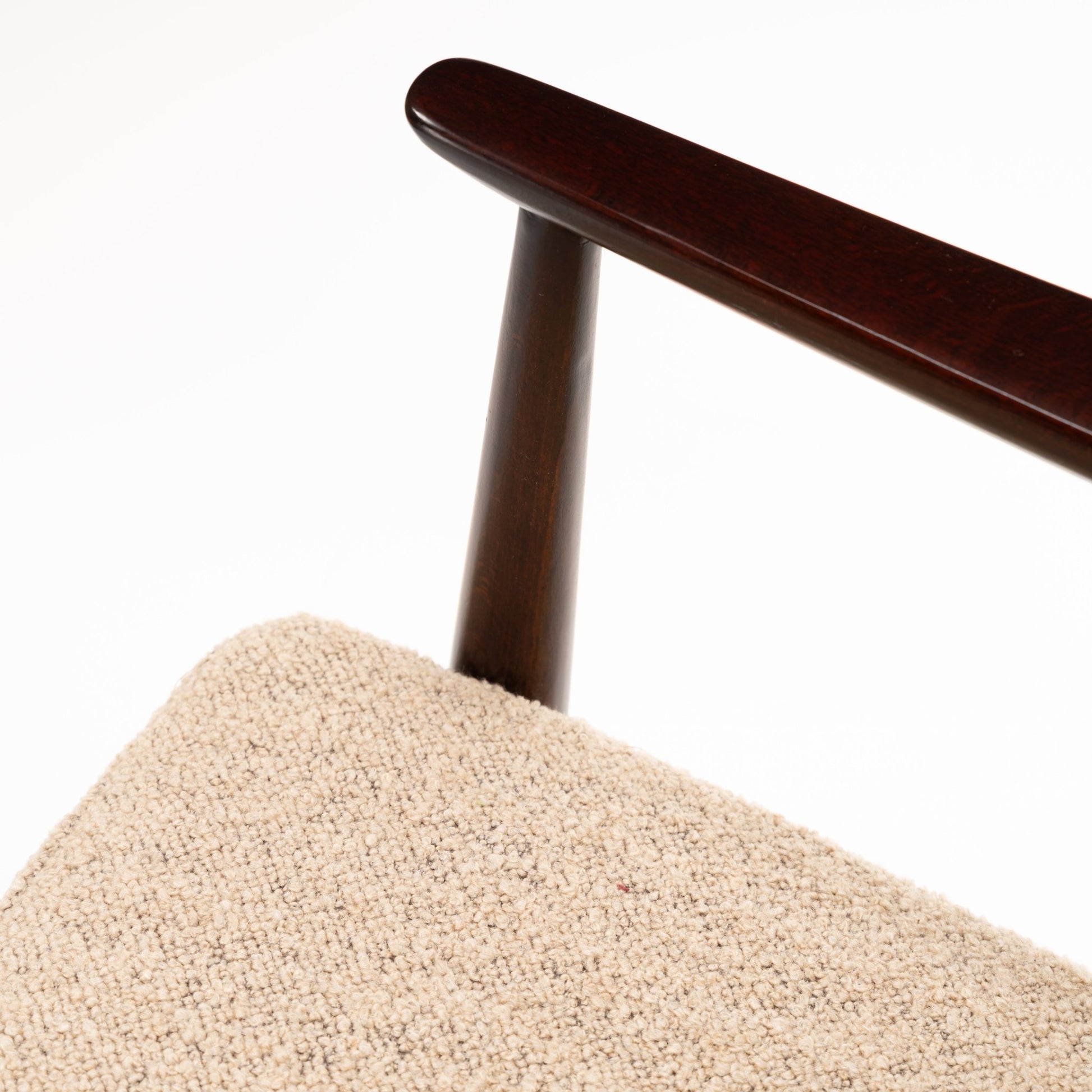Peter Hvidt Model FD 145 Lounge Chair close detail of rounded dark wood back rail and post above textured beige upholstery in vintage Danish furniture style