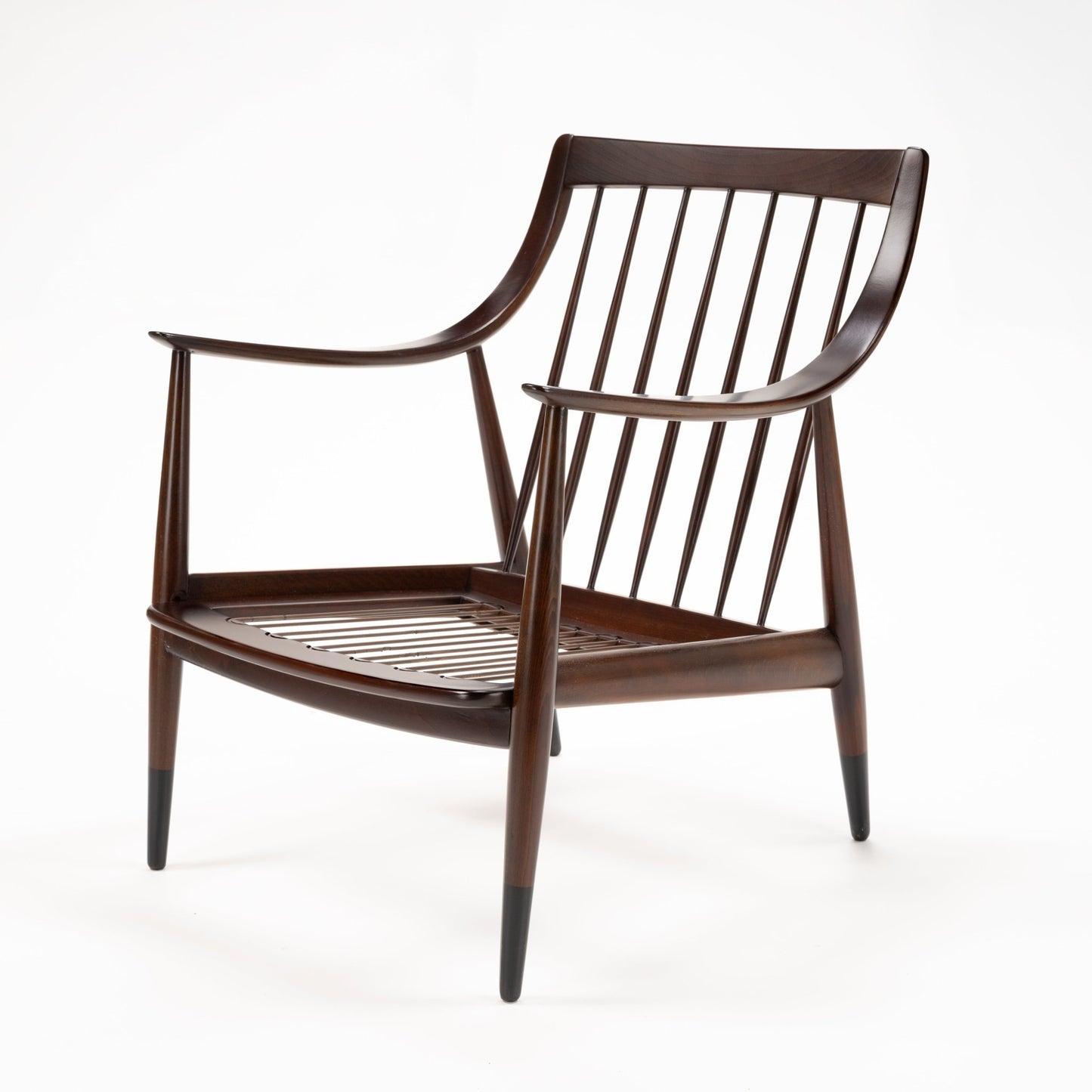 Peter Hvidt Model FD 145 Lounge Chair in dark wood with sculpted arms spindle back and tapered legs in vintage Danish furniture style