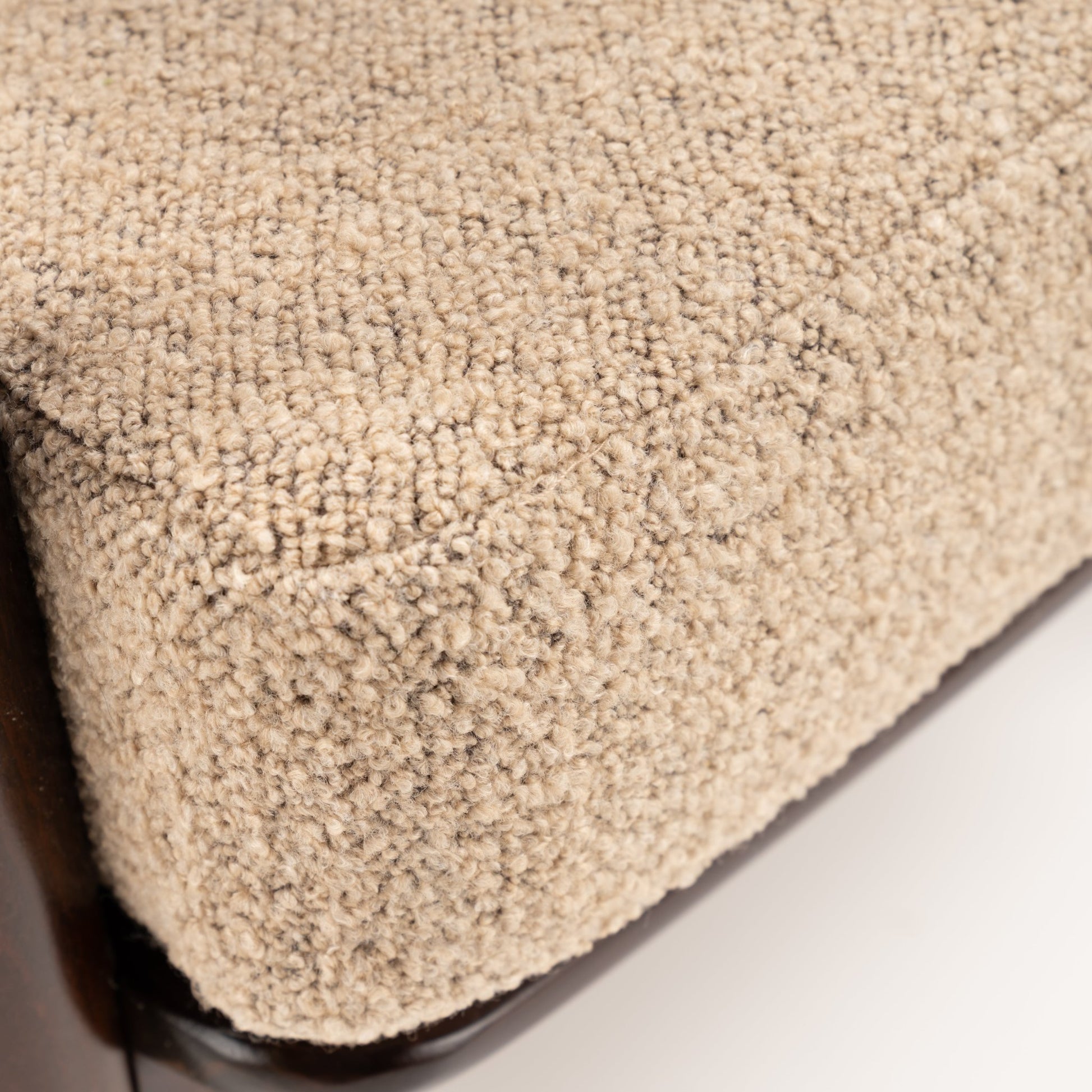 Peter Hvidt Model FD 145 Lounge Chair close view of textured beige boucle upholstery with rounded edge and dark wood frame in vintage Danish furniture style