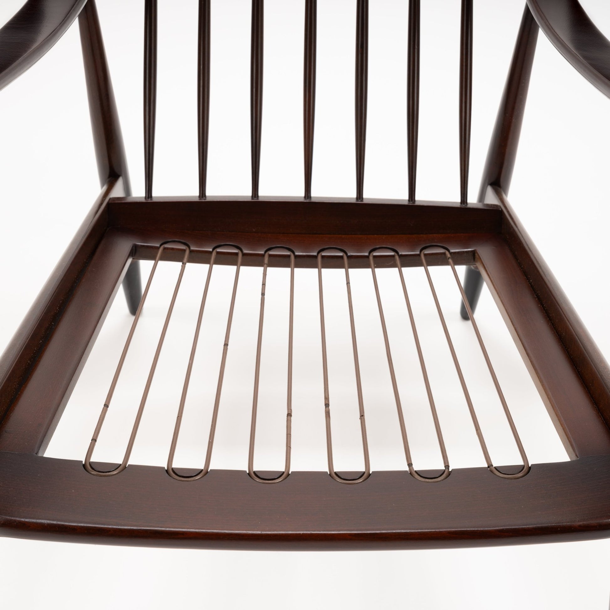 Peter Hvidt Model FD 145 Lounge Chair underside showing dark wood frame exposed metal seat springs and vertical back spindles in vintage Danish furniture style