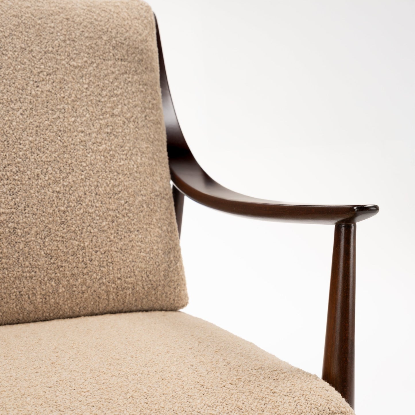 Peter Hvidt Model FD 145 Lounge Chair close detail of curved dark wood armrest and textured beige upholstery in vintage Danish furniture style