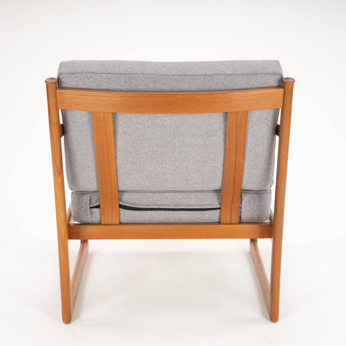 Rear view of a wooden armchair with light grey cushions and a simple, straight backrest frame on white background