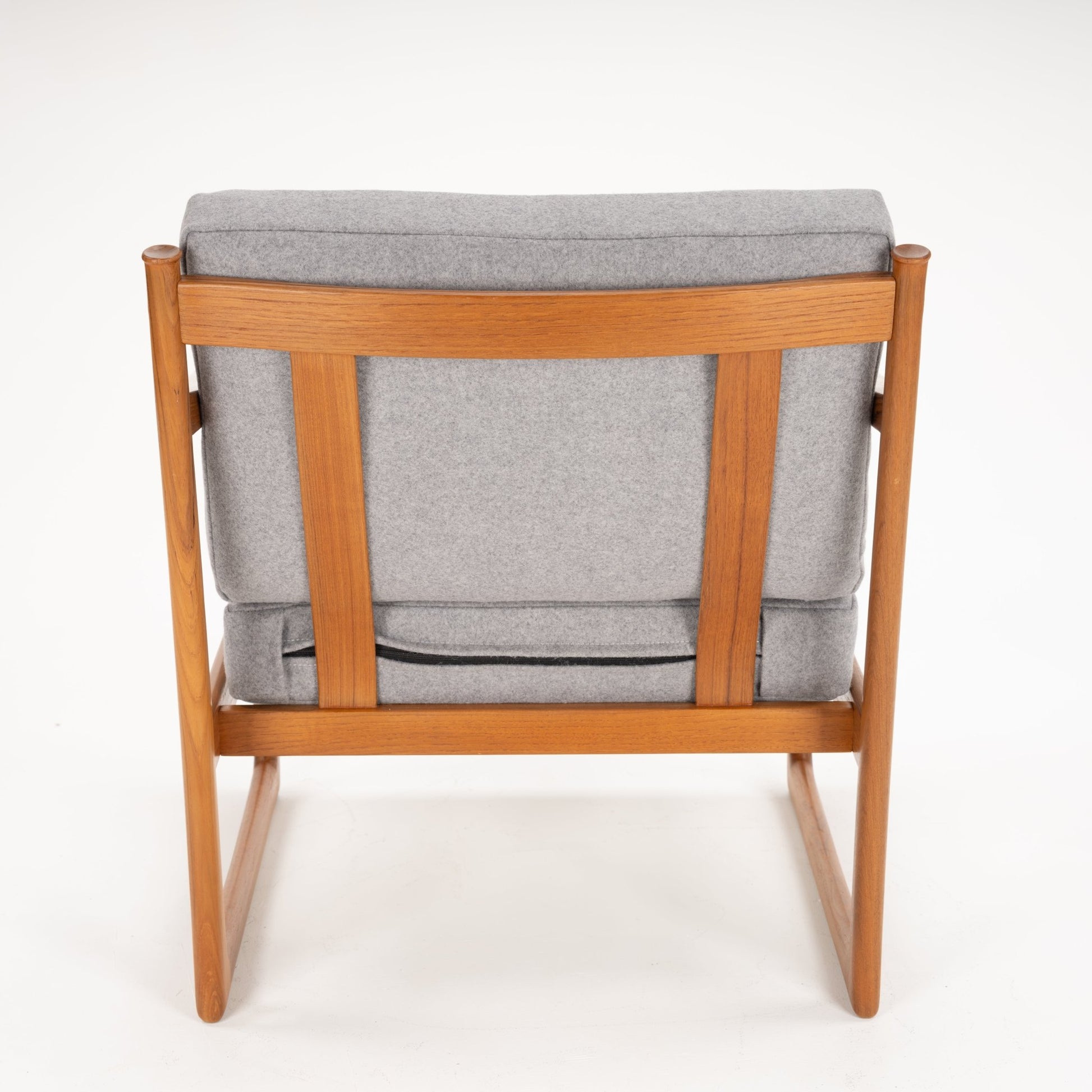 Rear view of a wooden armchair with light grey cushions and a simple, straight backrest frame on white background