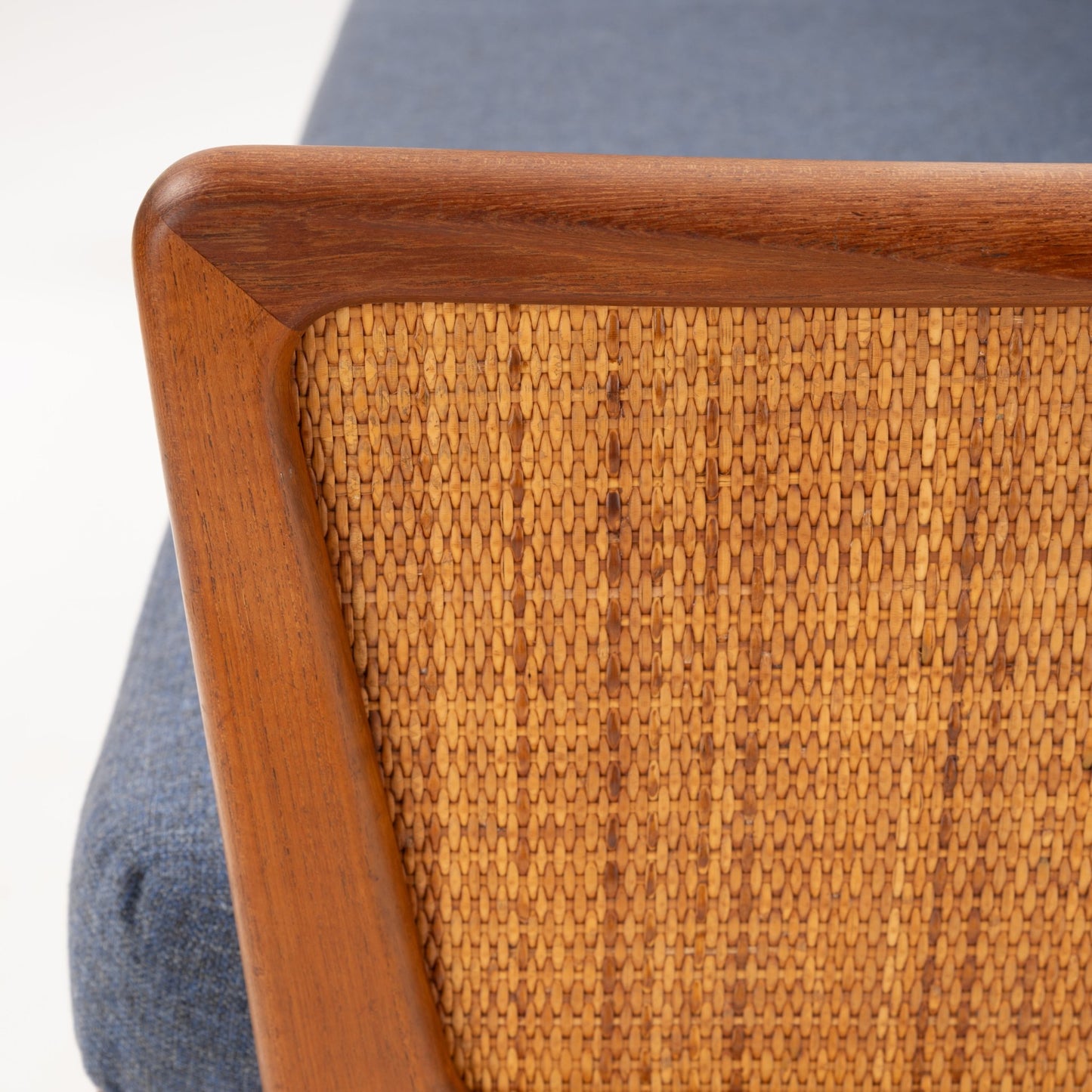 Peter Hvidt & Orla Molgaard Model FD 451 Daybed/Sofa close up of woven cane back teak frame and blue cushion in vintage Danish furniture style