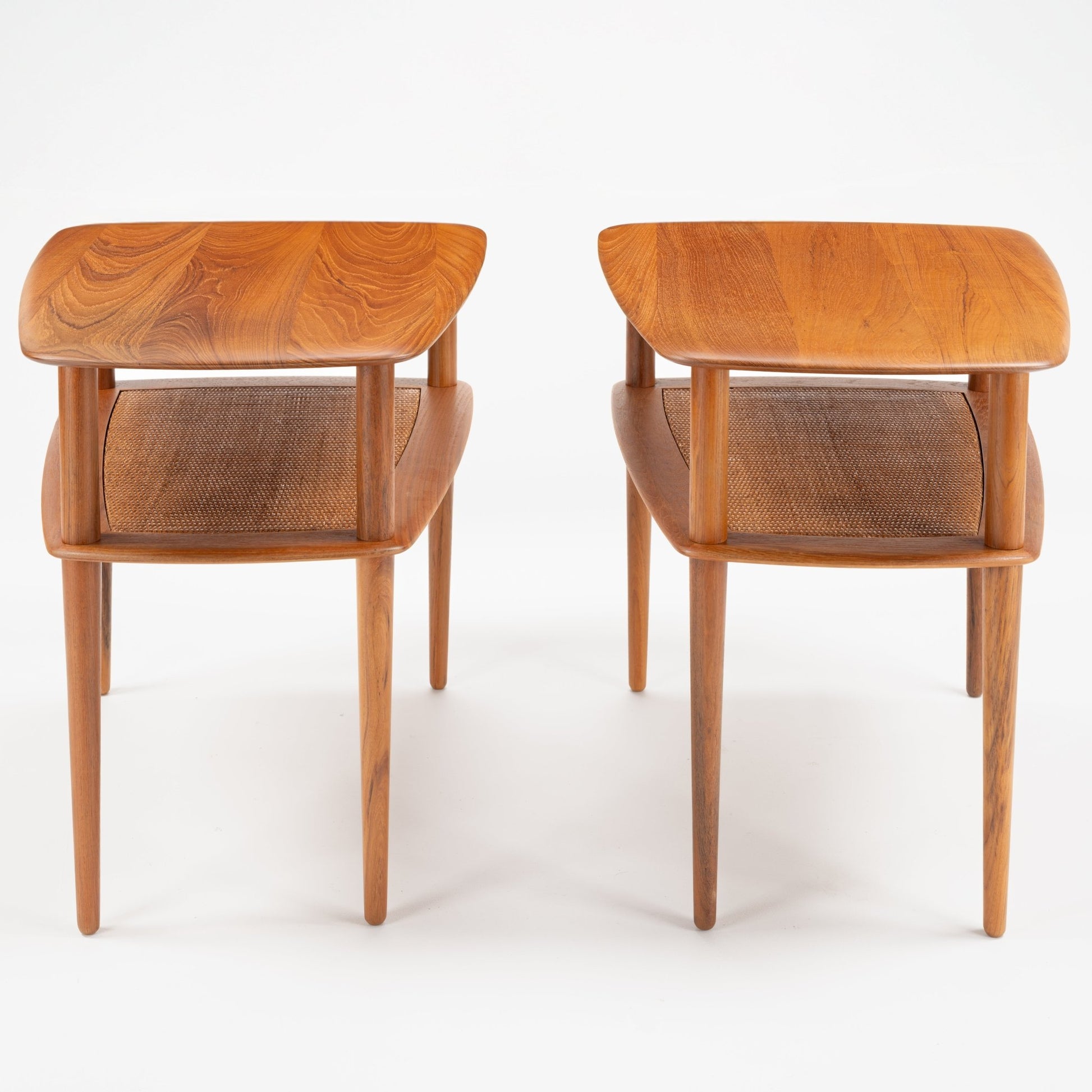 Peter Hvidt & Orla Molgaard Pair of End Tables featuring rounded wooden tops with visible wood grain and woven lower shelves supported by slender, tapered legs in a refined mid century modern style.