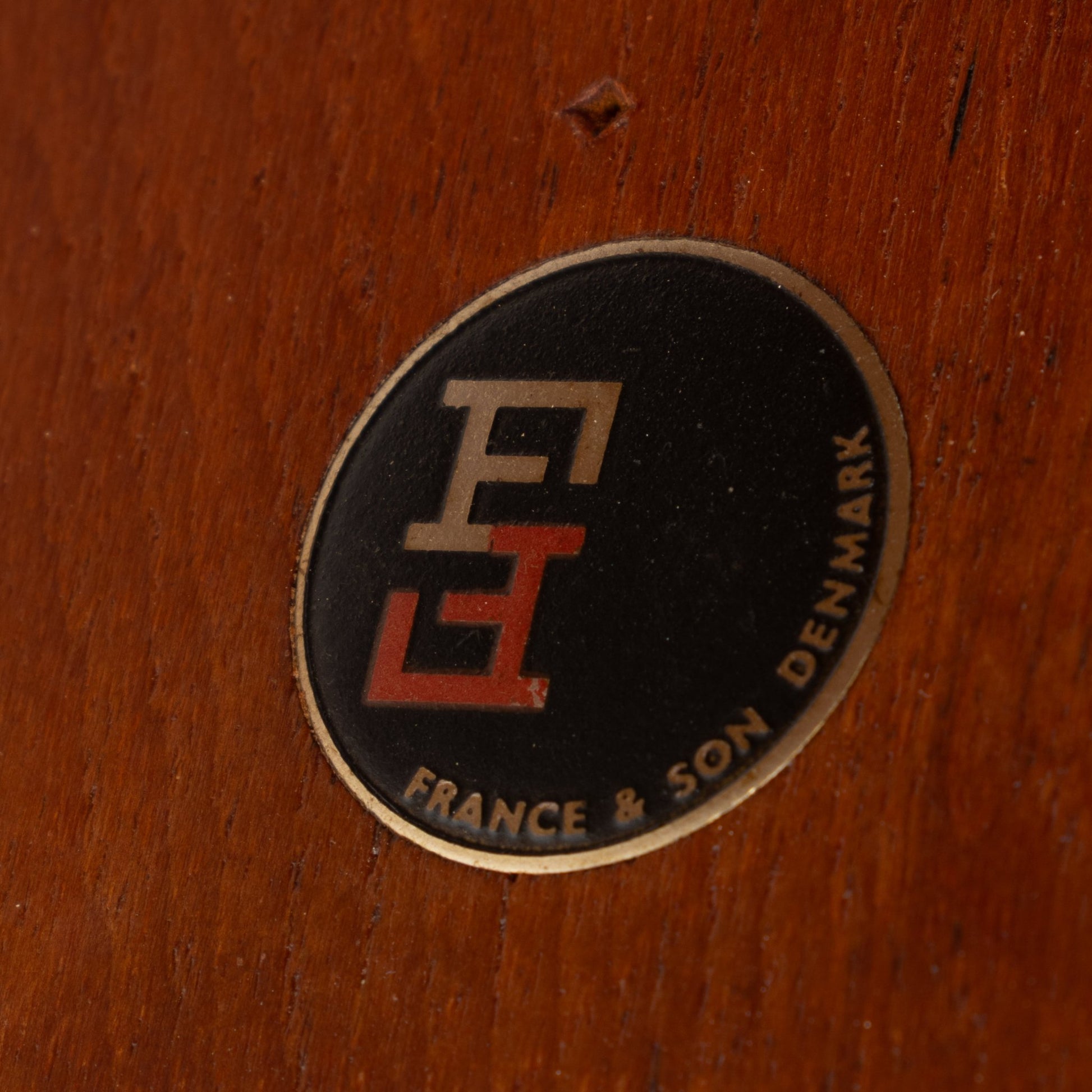 Peter Hvidt & Orla Molgaard Pair of End Tables close-up of a vintage France & Son Denmark maker's label on warm-toned wood, highlighting authentic mid century modern furniture craftsmanship.