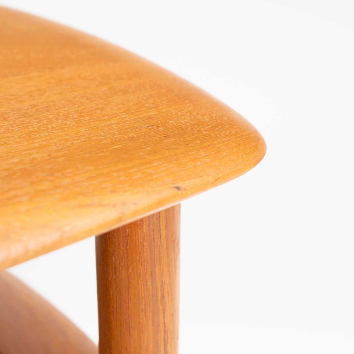 Peter Hvidt & Orla Molgaard Pair of End Tables featuring a close-up of the smooth rounded wooden top and a sturdy rounded leg, exemplifying mid century modern furniture design.