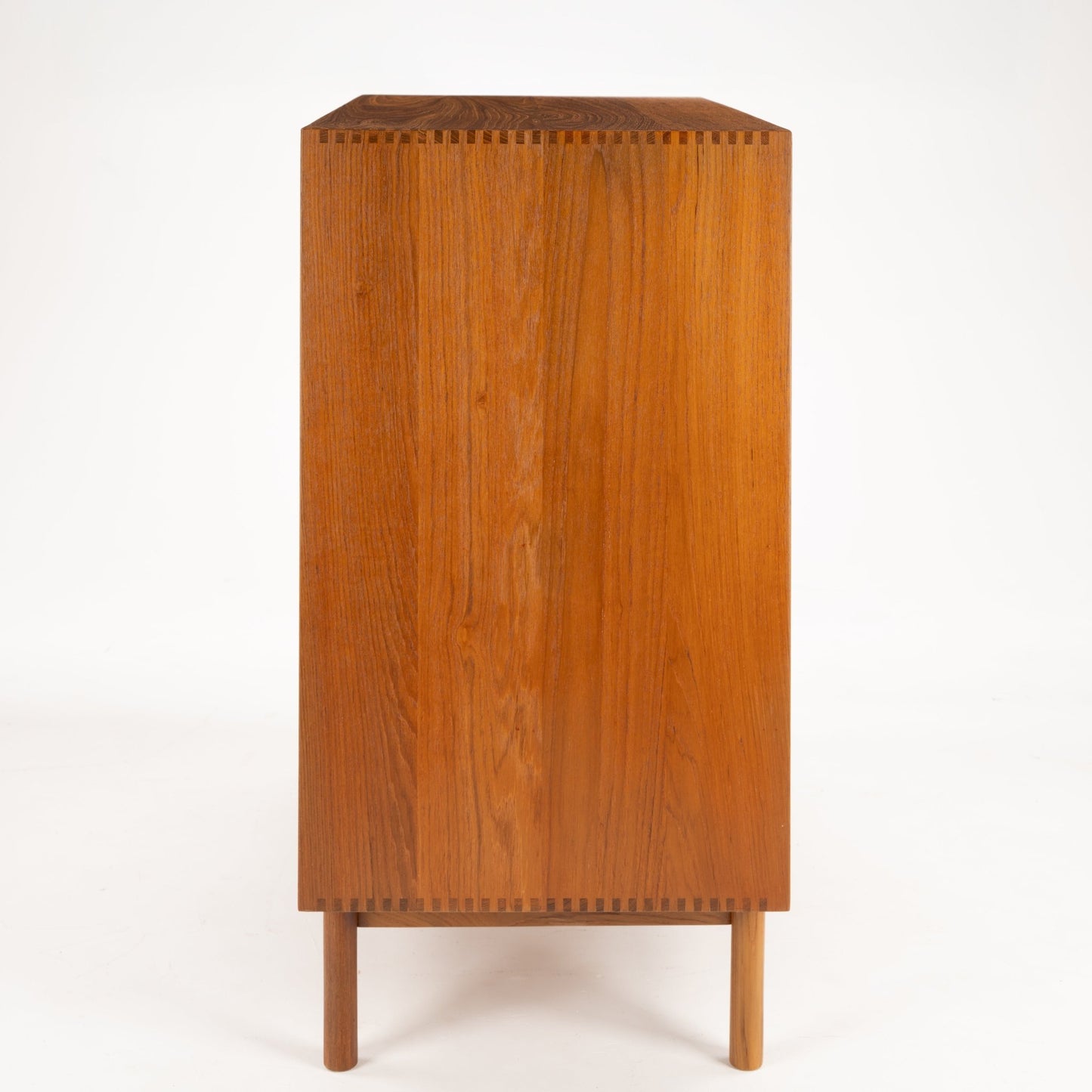 Peter Hvidt & Orla Nielsen Teak Chest of Drawers showing a side view with clean lines, warm teak wood grain, and fine dovetail joinery on slender round legs in vintage Danish mid century modern style.