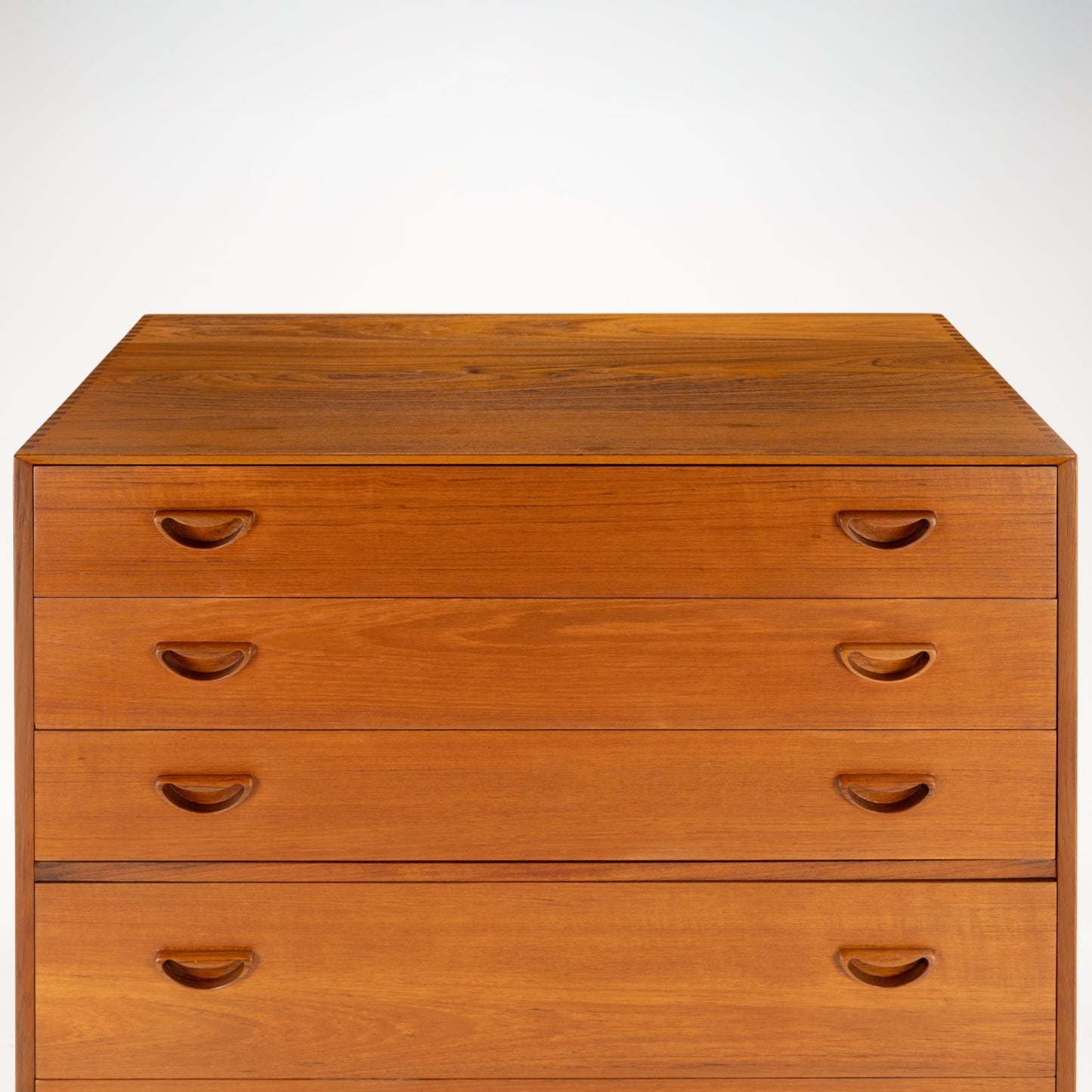 Peter Hvidt & Orla Nielsen Teak Chest of Drawers showcasing warm teak wood with four drawers featuring carved recessed handles and a clean, elegant mid century modern design.