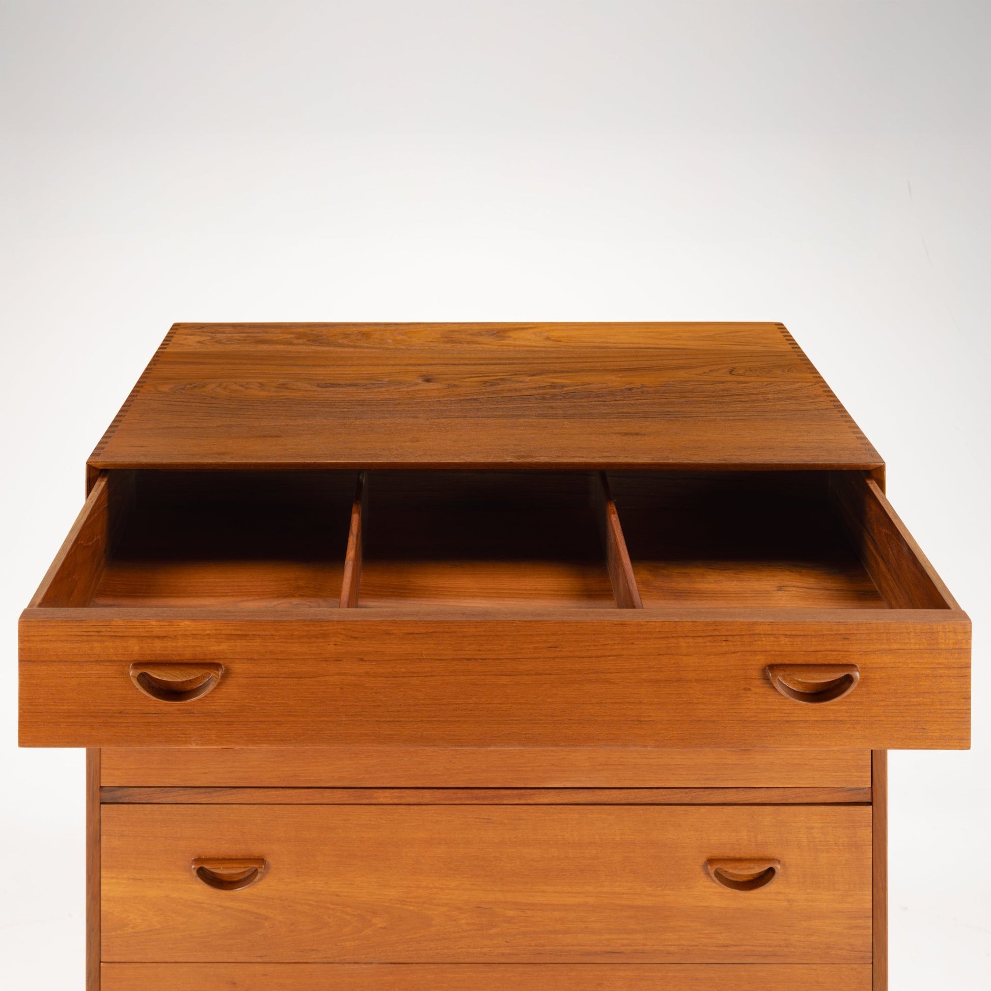 Peter Hvidt & Orla Nielsen Teak Chest of Drawers featuring warm teak wood with an open top drawer divided into three compartments and distinctive curved recessed handles in vintage mid century modern style.