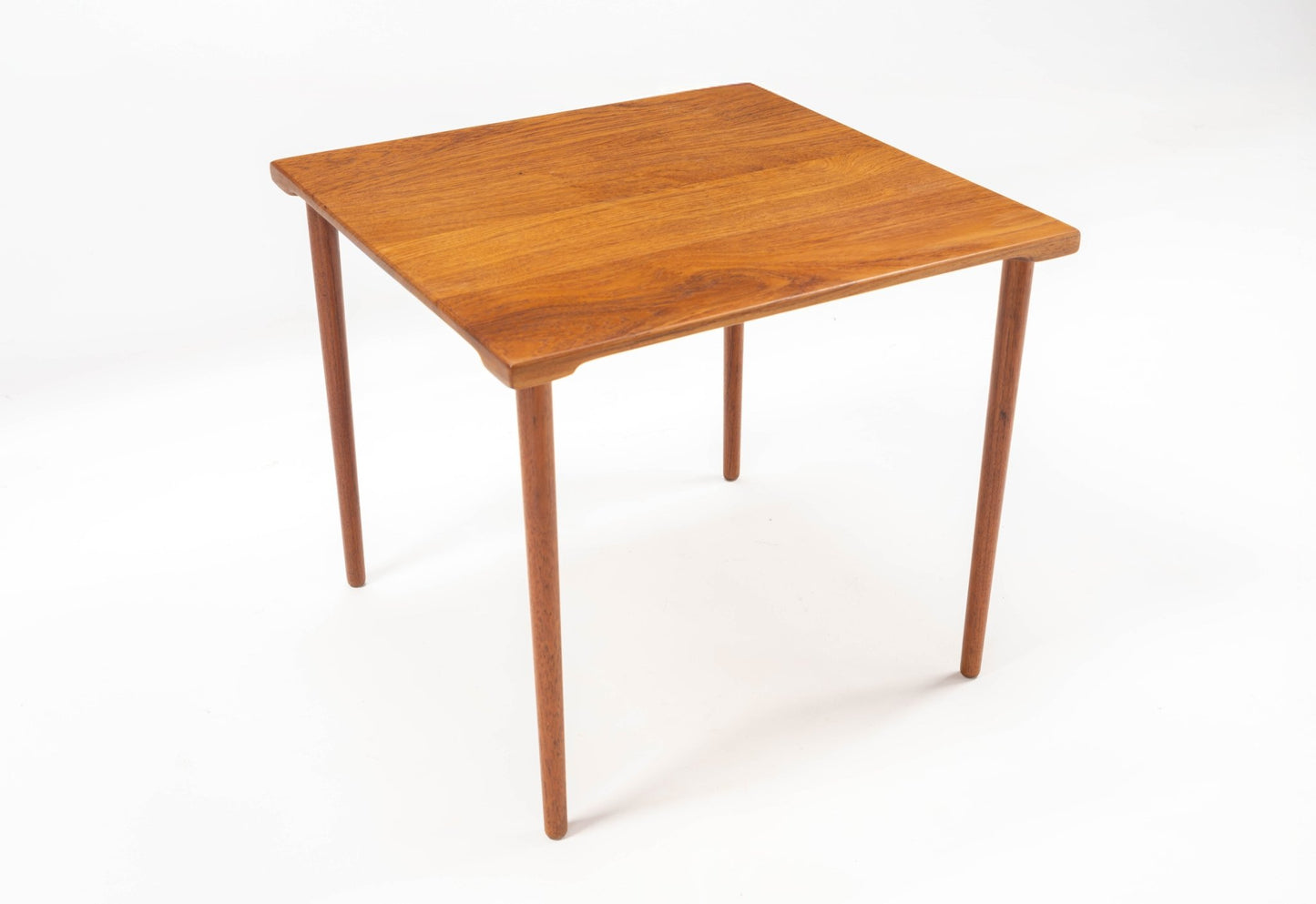 Square mid-century modern teak side table with slender dowel legs and smooth grained wood top on white background
