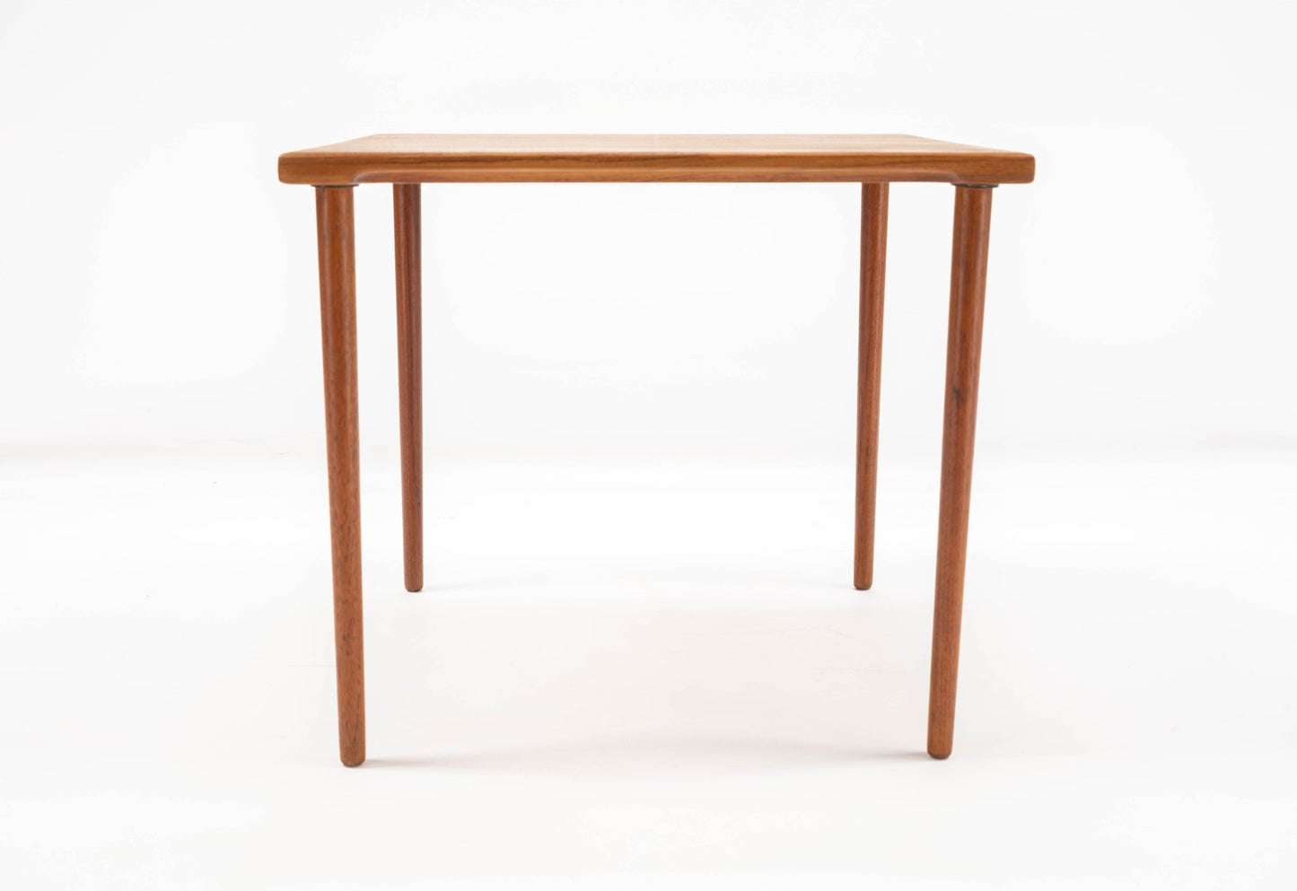 1960s Danish teak side table by Peter Hvidt with slender dowel legs and solid teak slab top on white background