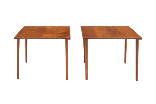Pair of 1960s Peter Hvidt solid teak side tables with slender dowel legs and richly grained tops on white background