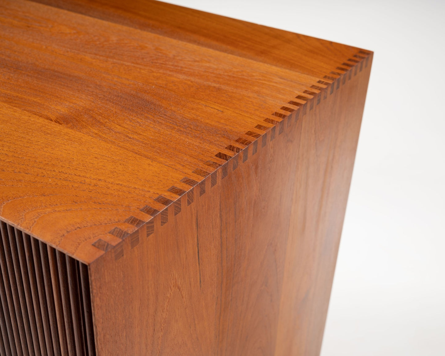 Close-up of solid Burmese teak corner with dovetail joints on 1950s Peter Hvidt tambour door cabinet.