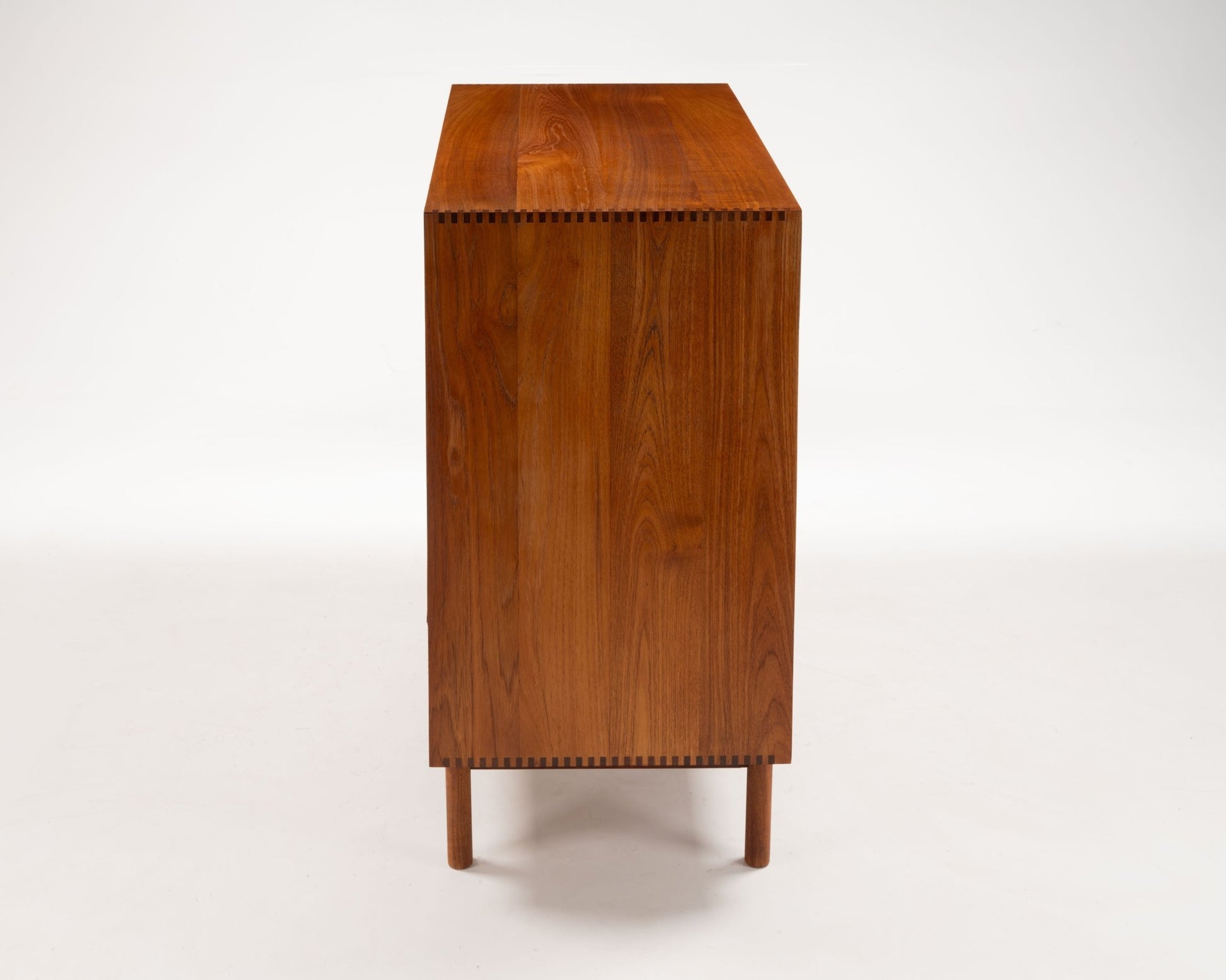 Side view of Peter Hvidt teak tambour door cabinet with dovetail joints and slender legs from the 1950s Danish modern design
