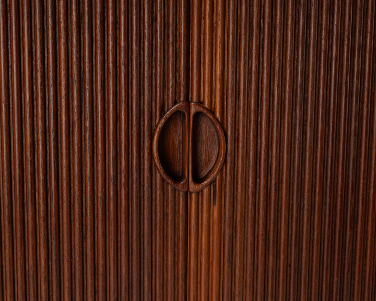 Close-up of Peter Hvidt teak tambour door cabinet handles with vertical slatted design from the 1950s Danish modern era