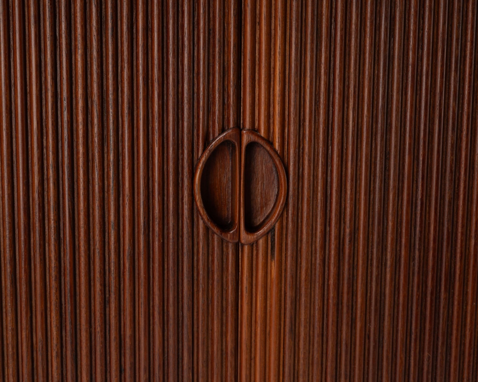 Close-up of Peter Hvidt teak tambour door cabinet handles with vertical slatted design from the 1950s Danish modern era