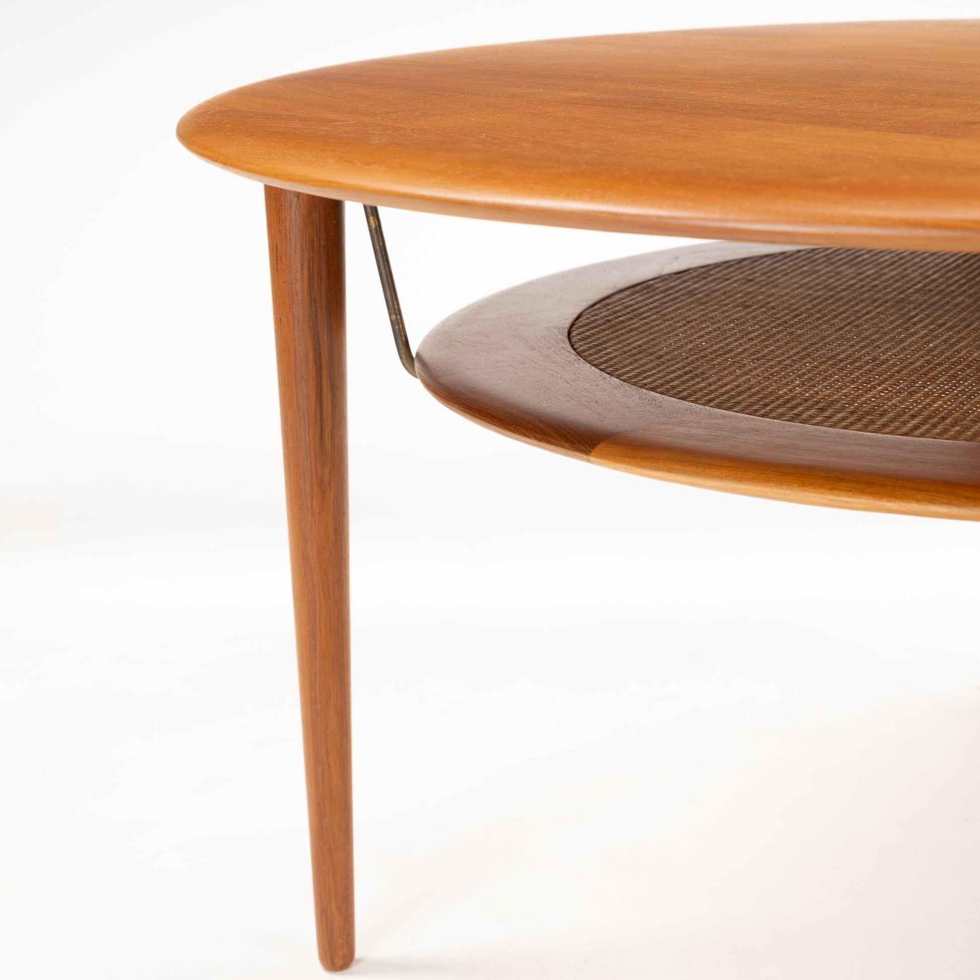 Peter Hvidt Teak Coffee Table Model FD-515 featuring a smooth round teak top with a woven lower shelf, supported by slender tapered legs in classic mid century modern style.