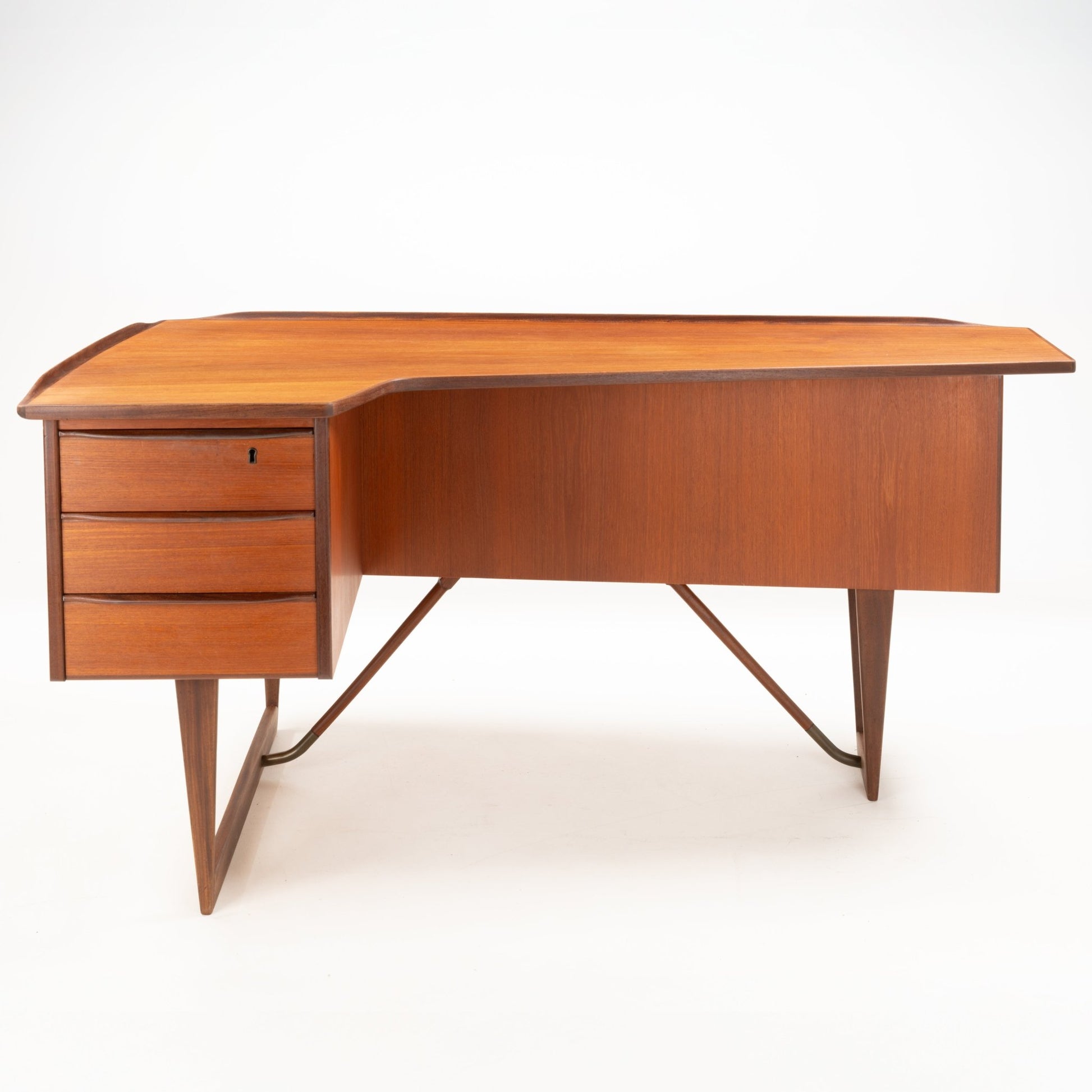 1960s Danish teak writing desk with asymmetrical boomerang-shaped top and three drawers on tapered legs